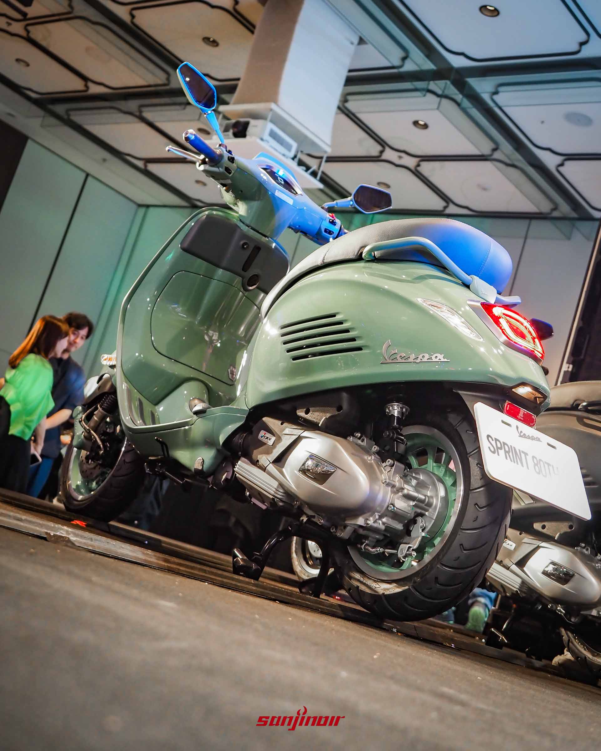 從低角度斜後方拍攝綠色Vespa Sprint80周年特仕版,展示豐滿的車尾輪廓與懸吊排氣管細節。