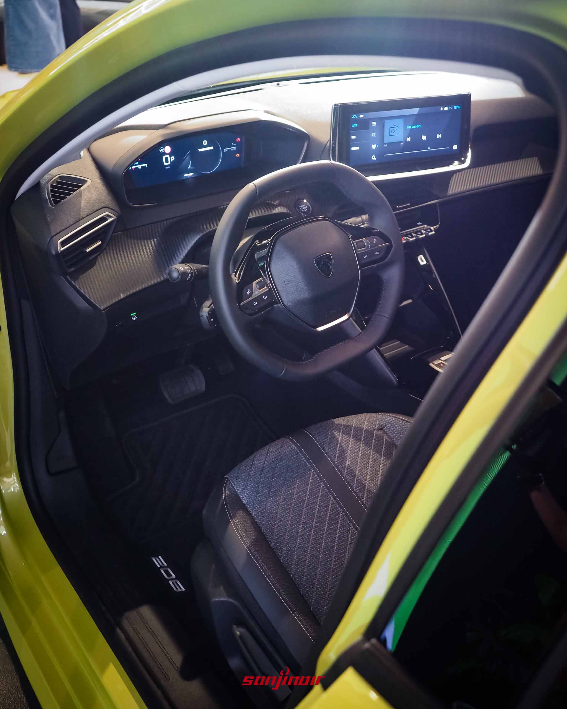 PEUGEOT 208 P2 Hybrid的前座內裝全景,從左前車門視角拍攝,展示小盤徑方向盤、懸浮式數位儀錶板以及10吋中控觸控螢幕。
