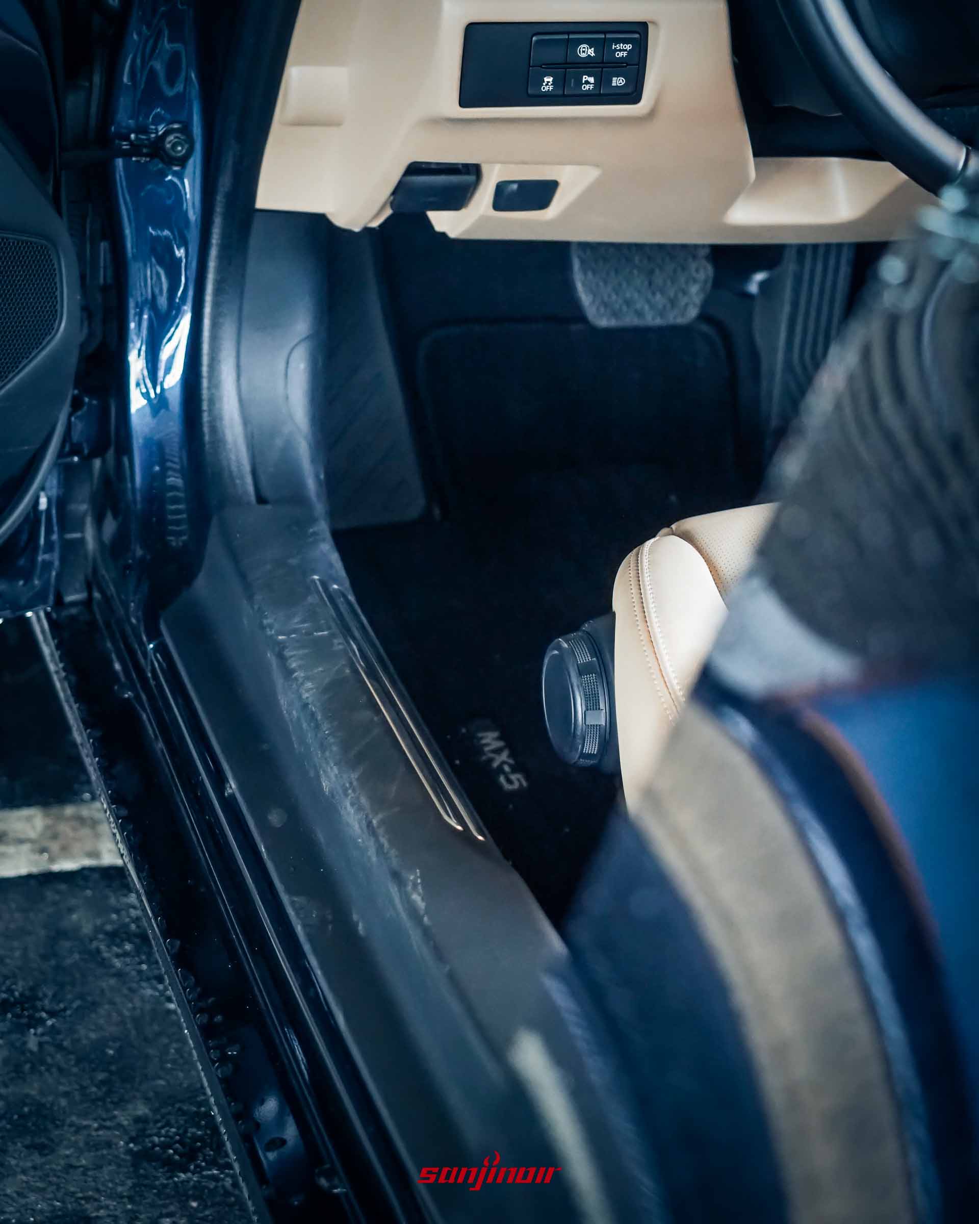 Mazda MX-5 RF 打開車門視角,展示金屬迎賓門檻踏板、低矮的乘坐設定與部分棕色皮椅。