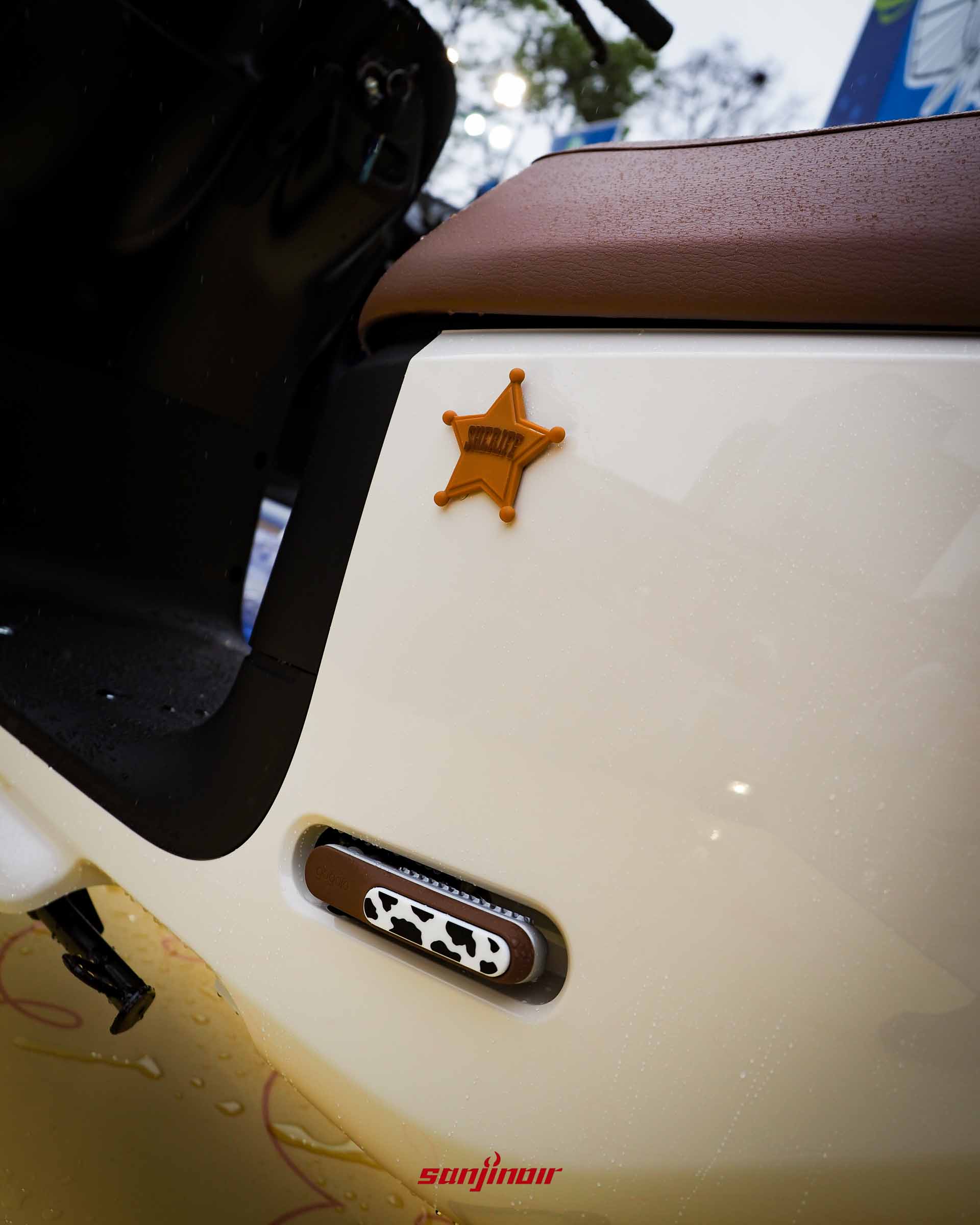 Gogoro EZZY 500歡樂牛仔號側邊特寫，展示立體警長徽章與乳牛紋路的飛旋踏板。