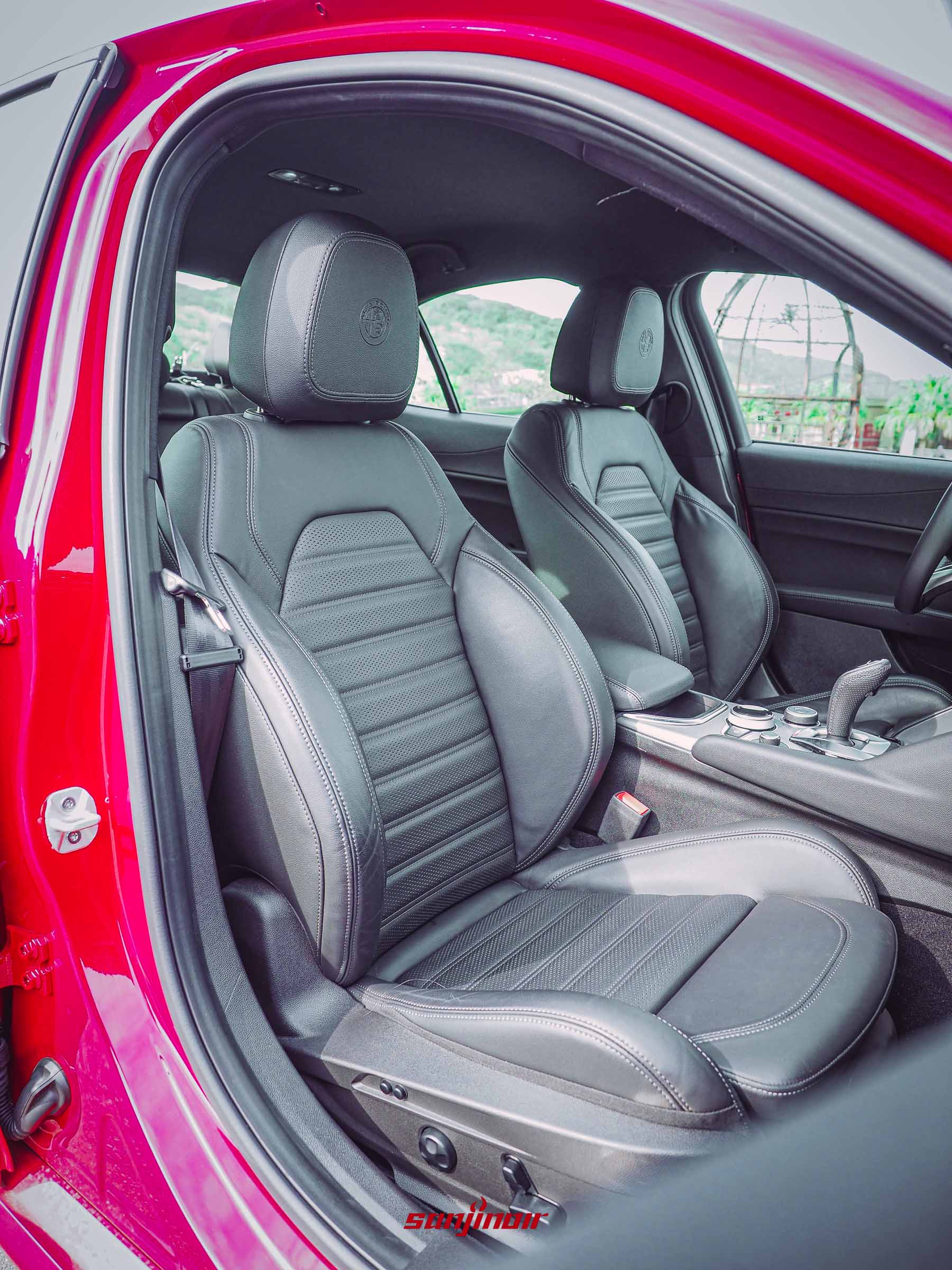 Alfa Romeo Giulia Sprint前座座椅特寫,展示黑色皮革紋理與頭枕廠徽壓印。