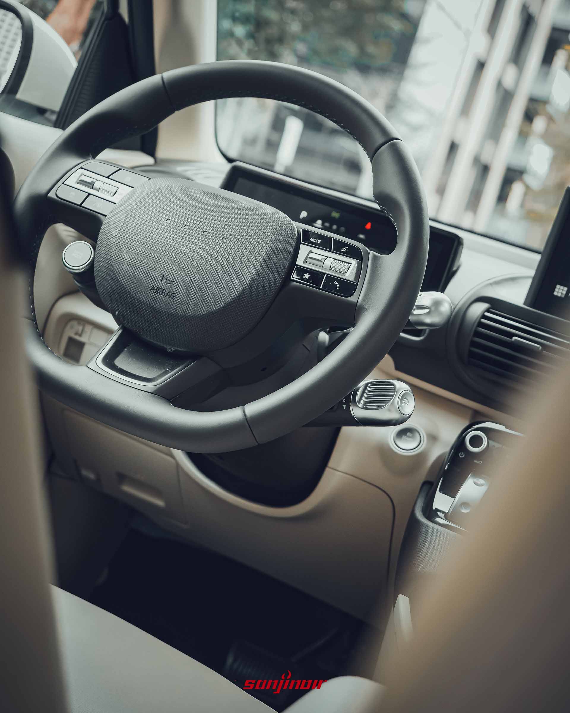 Hyundai Inster 方向盤特寫，強調中央像素點陣與控制按鍵。