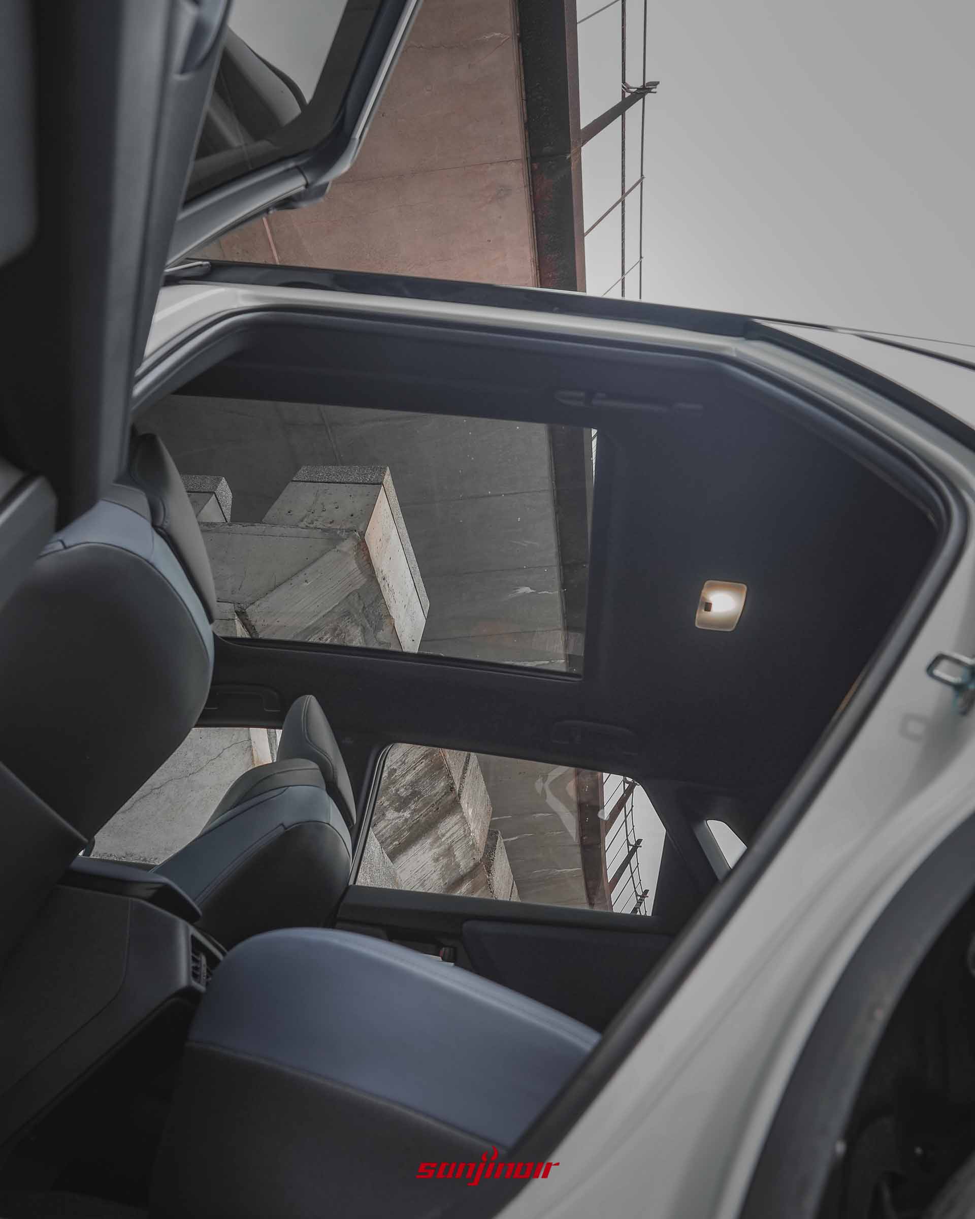 由Subaru Solterra XT後座仰望開啟的全景式天窗，可見車外的橋樑結構。