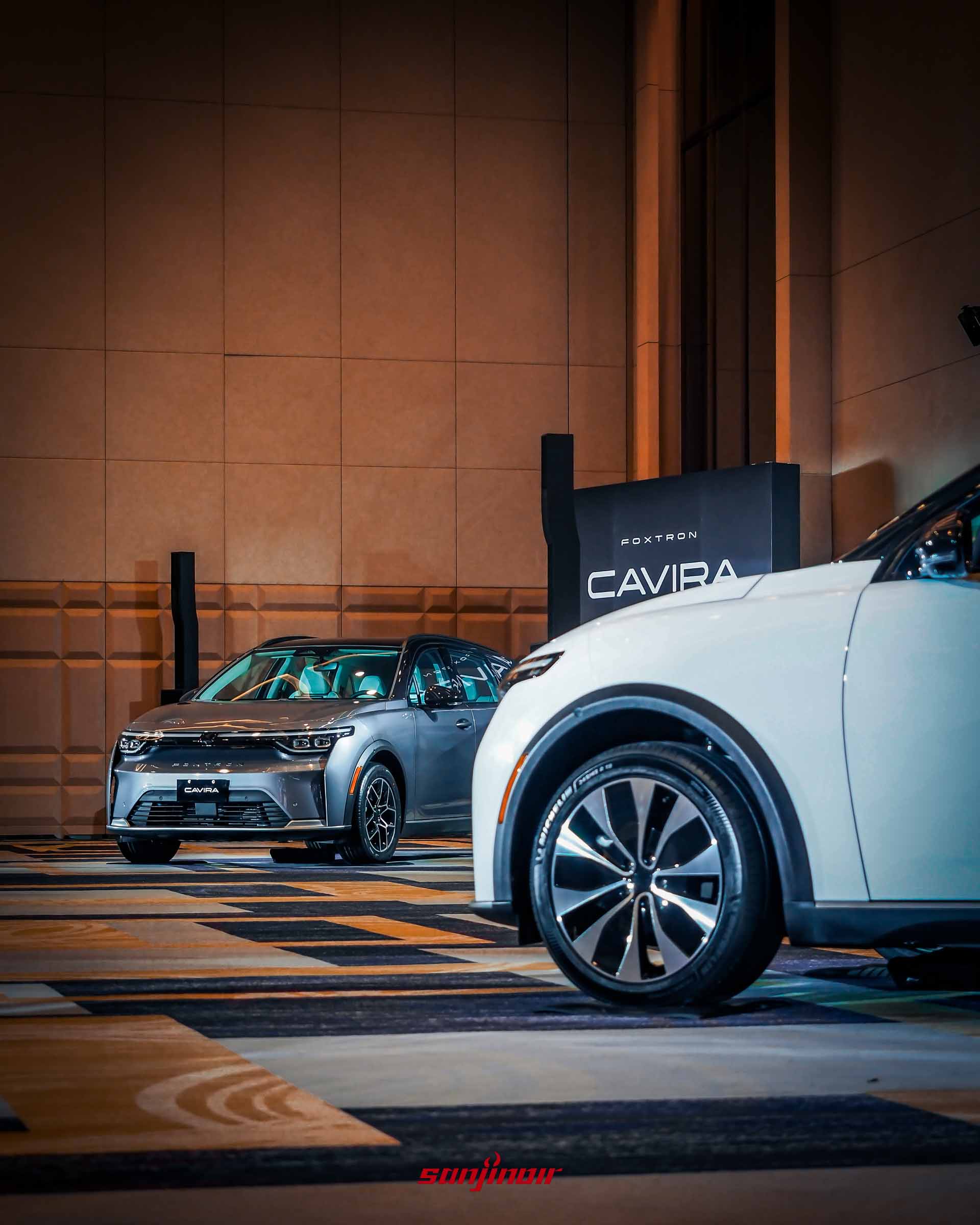發表會現場展示兩輛Foxtron Cavira,前方為白色車款局部,後方為灰色車款全車正面,背景為Cavira品牌字樣立牌。