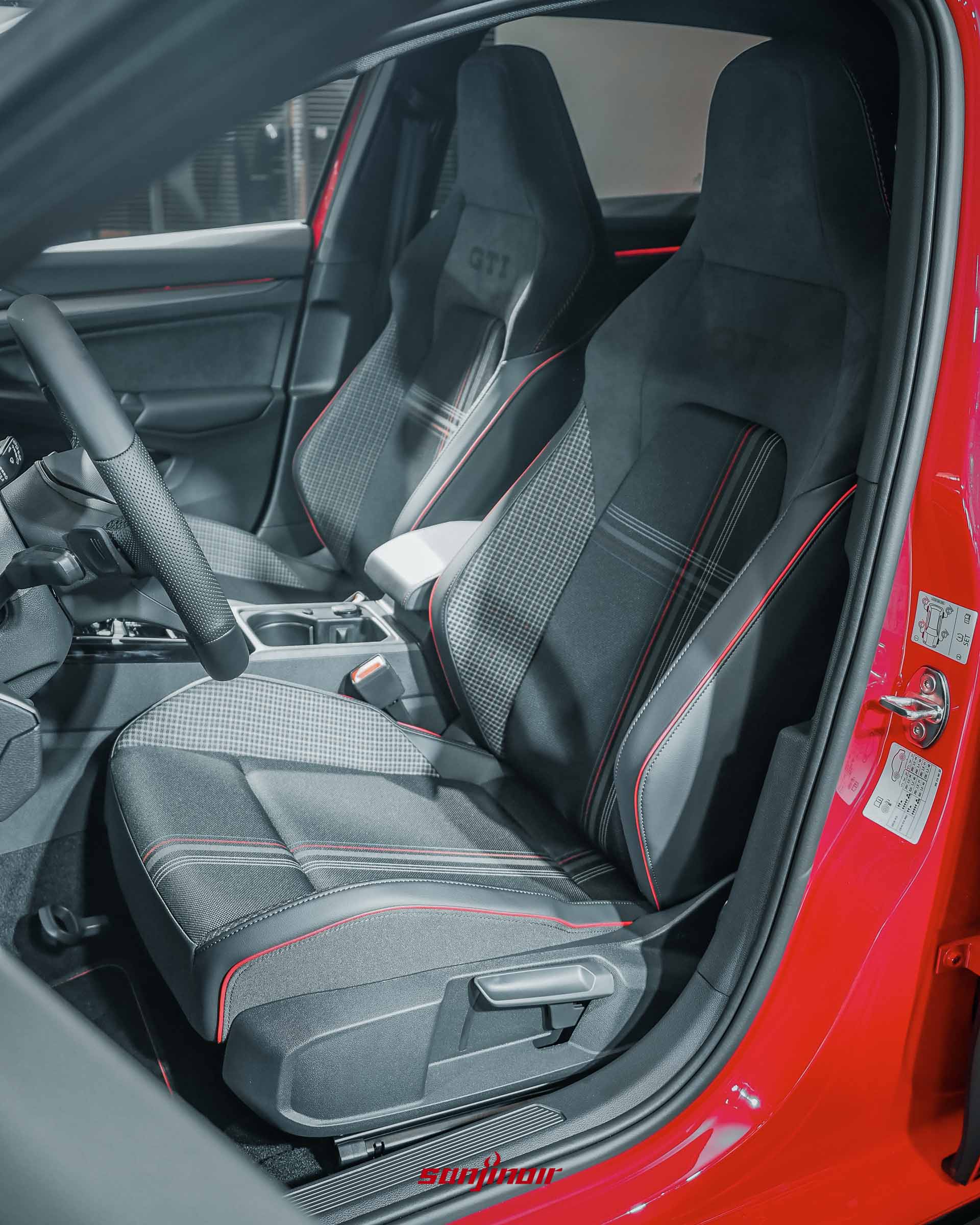 Golf GTI EDITION 50的前座跑車型座椅，採用經典格紋設計結合類麂皮材質，邊緣輔以紅色縫線點綴。