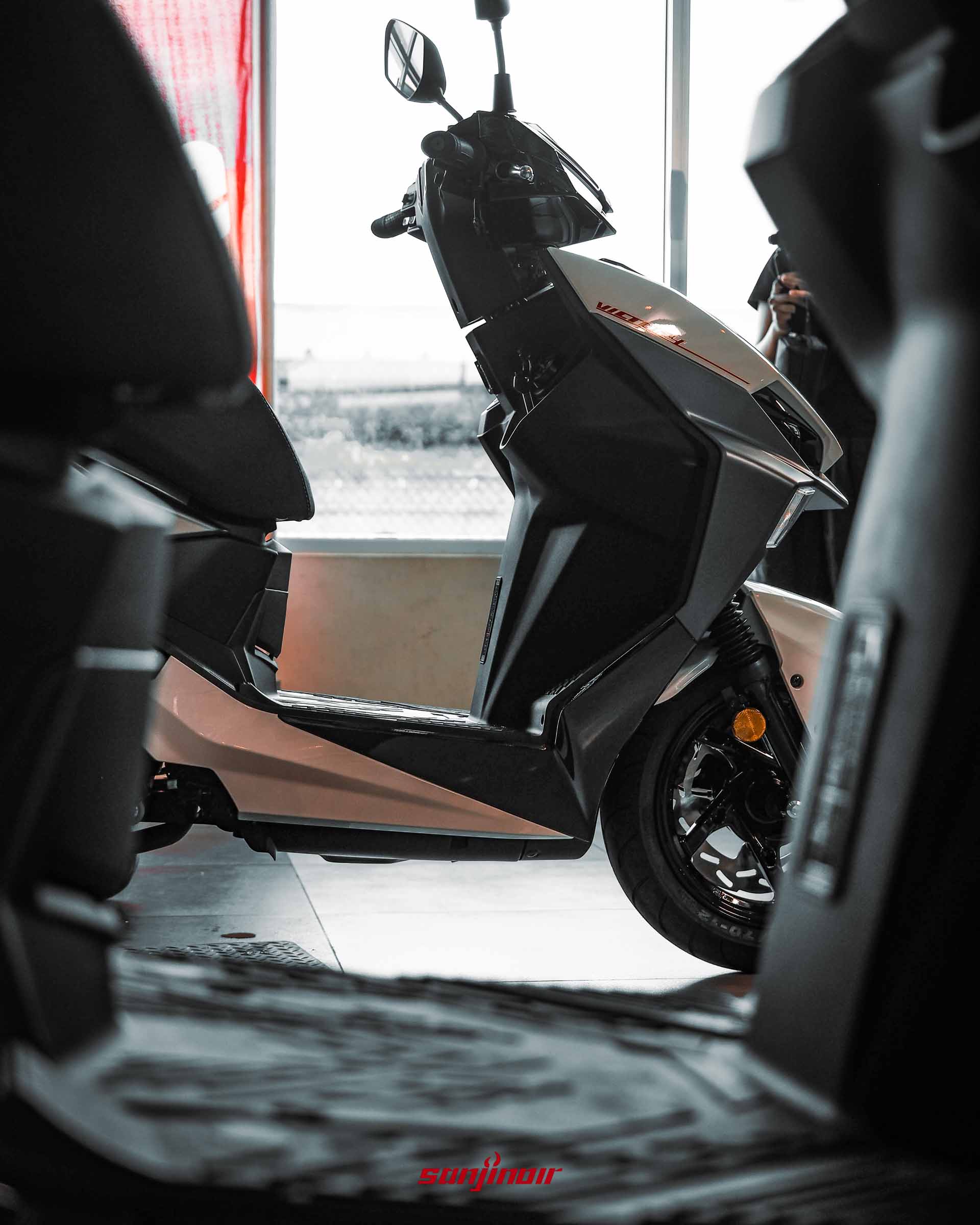 SYM Jet SL+ 車側腳踏板區域特寫，展示平整化的前置腳空間與後方傾斜的競技踏板設計。