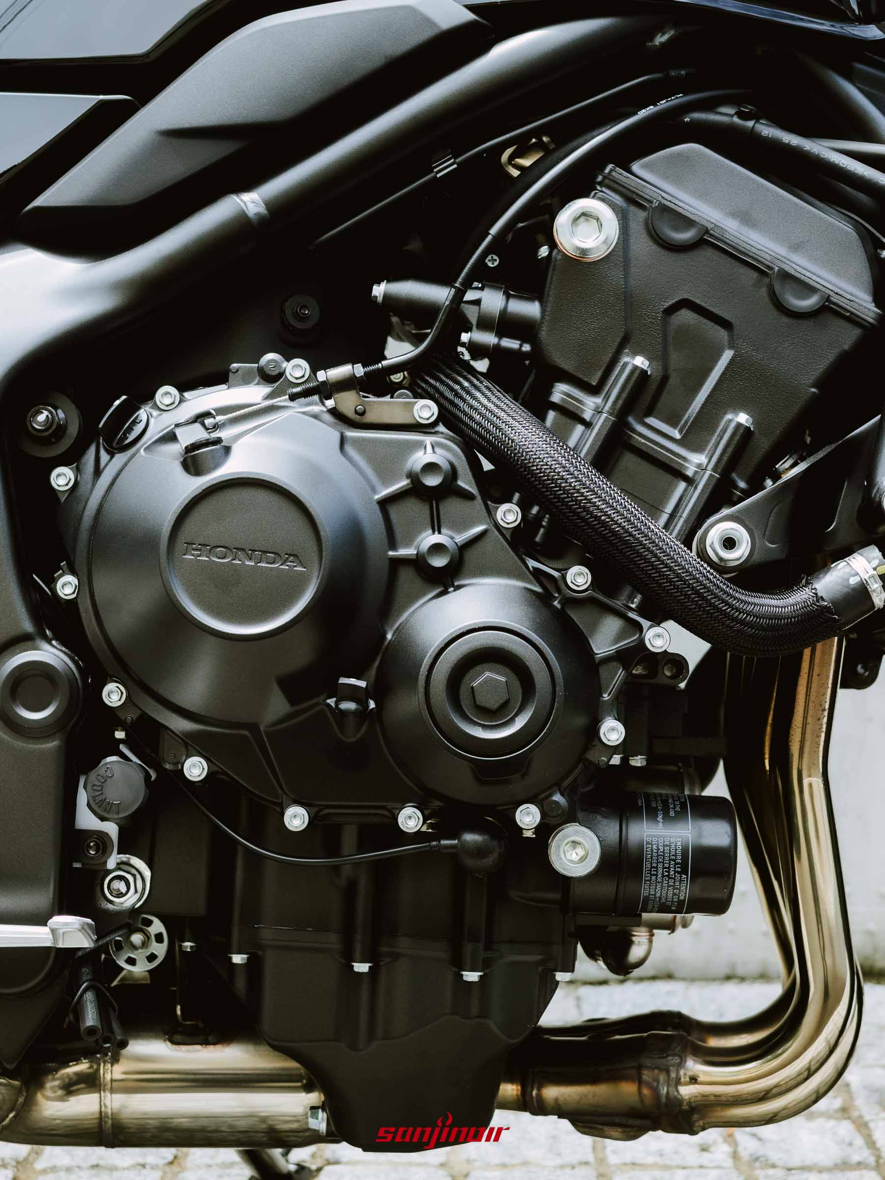 Honda CB1000F直列四缸引擎本體、曲軸箱外蓋與排氣管頭段的近距離特寫照片。