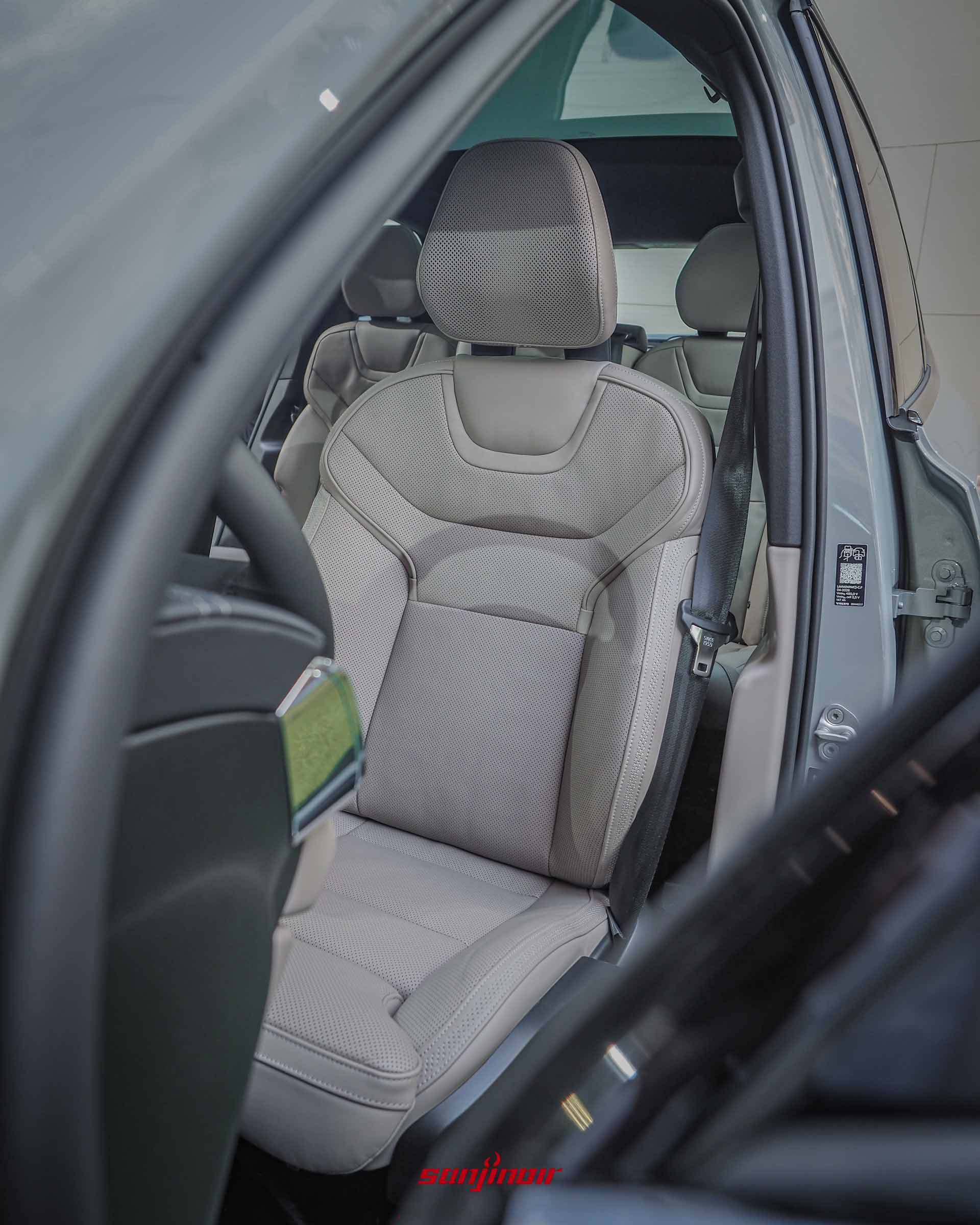 Volvo EX90前排座椅特寫,呈現淺米色皮質的打孔透氣細節、精緻的縫線與厚實的頭枕設計。