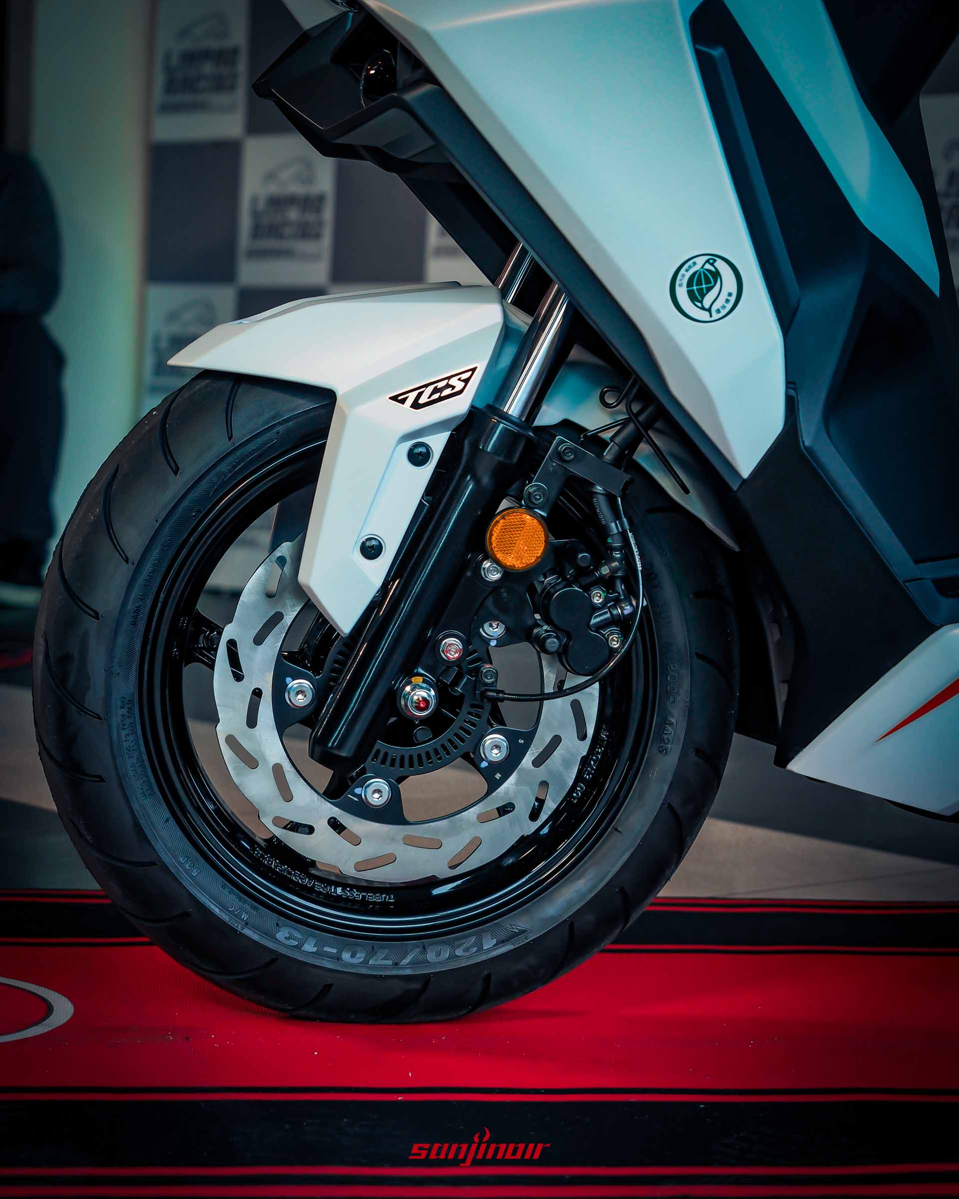 2026年式樣SYM DRGBT前輪總成特寫,包含輪框、碟盤、卡鉗與TCS貼紙。