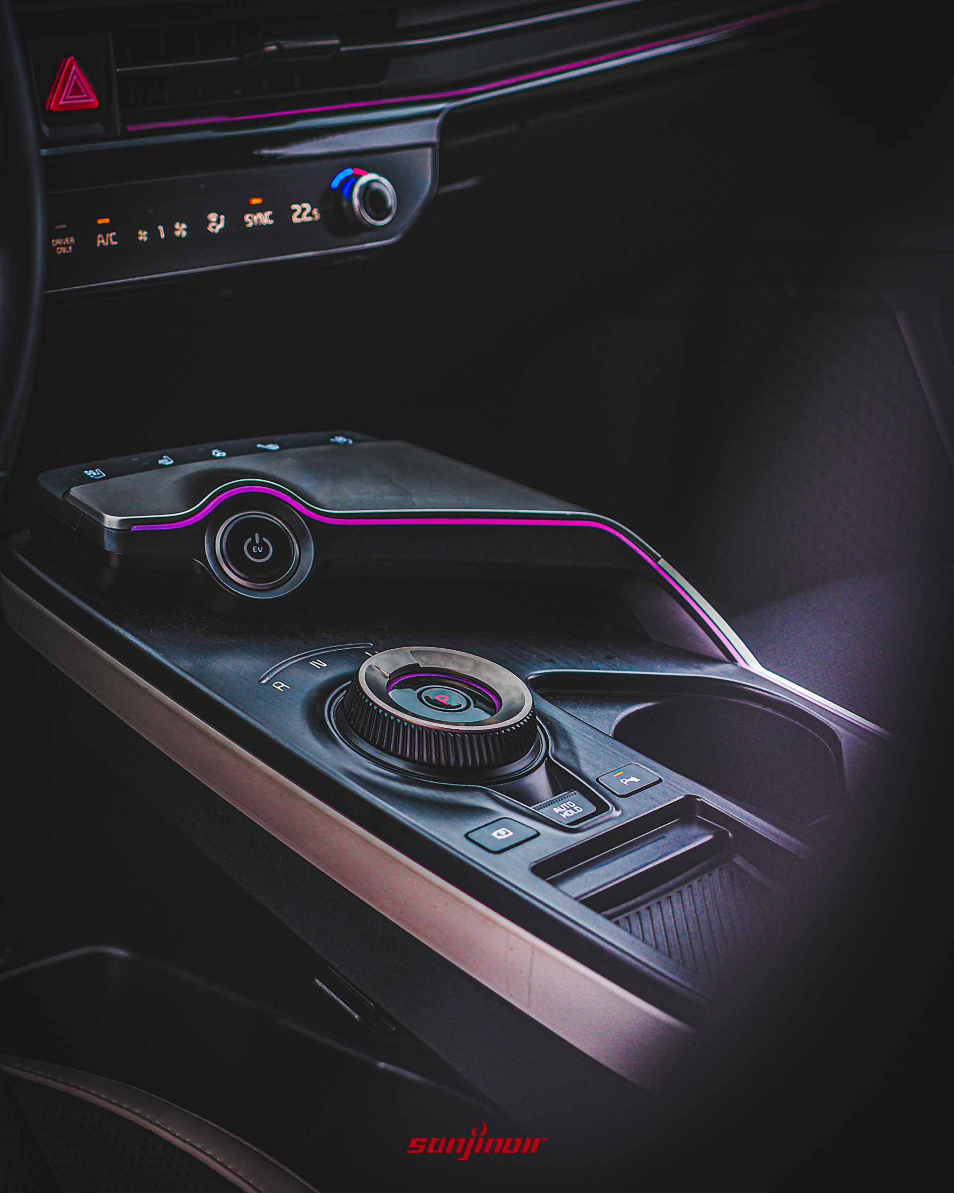 Kia EV6 GT-Line小改款中央鞍座特寫照片，展示髮絲紋飾板、旋鈕式排檔、電源鍵和粉紅色氛圍燈。