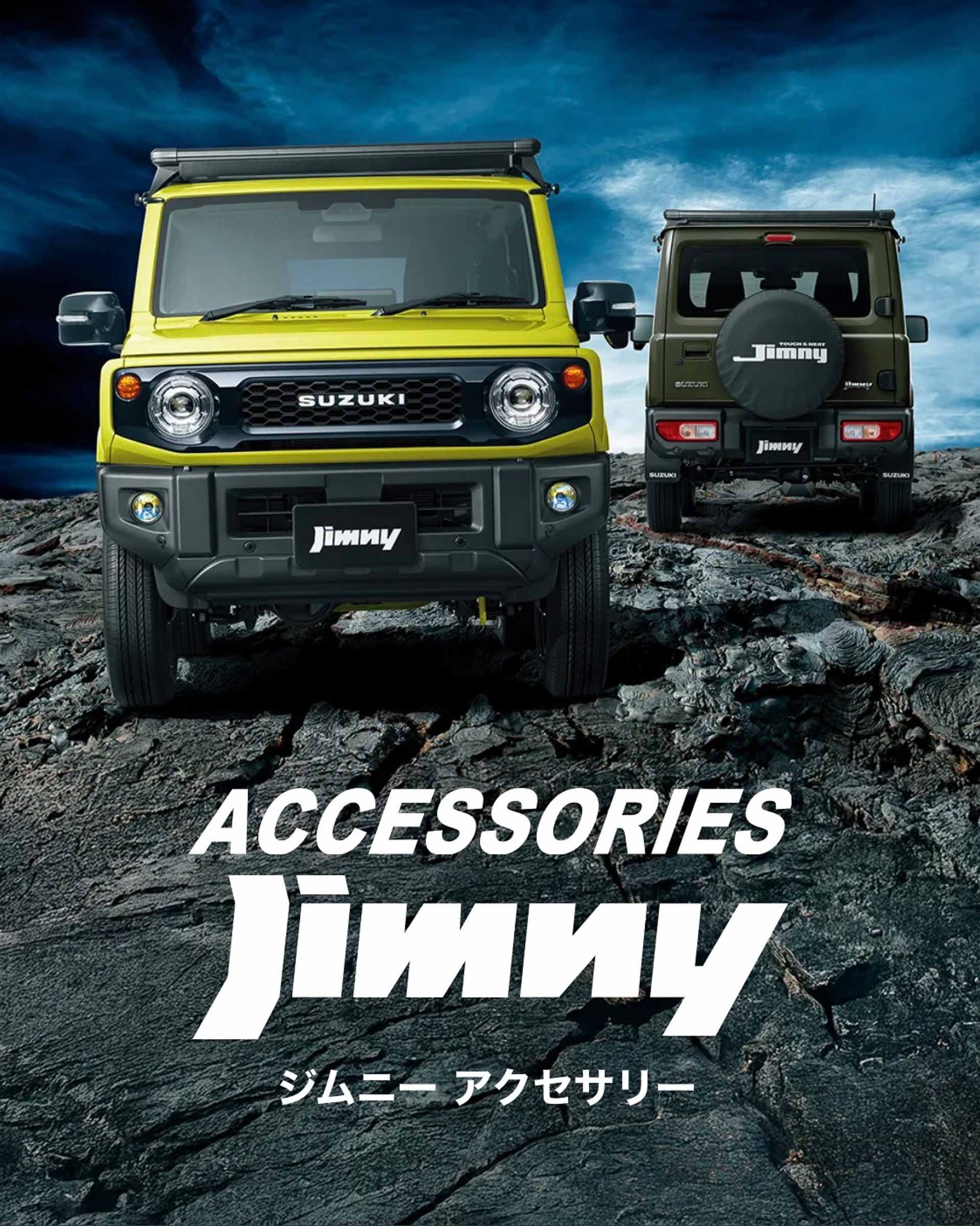 SUZUKI Jimny 日本原廠配件目錄封面的照片。畫面展示兩台 Jimny JB74：前景一台黃色的原廠 JB74 正面向前，背景一台深綠色配黑頂的 JB74 展現車尾，安裝了車頂箱和備胎蓋等配件。醒目文字寫著「ACCESSORIES」和「Jimny」，下方有較小的日文字「ジムニー アクセサリー」。