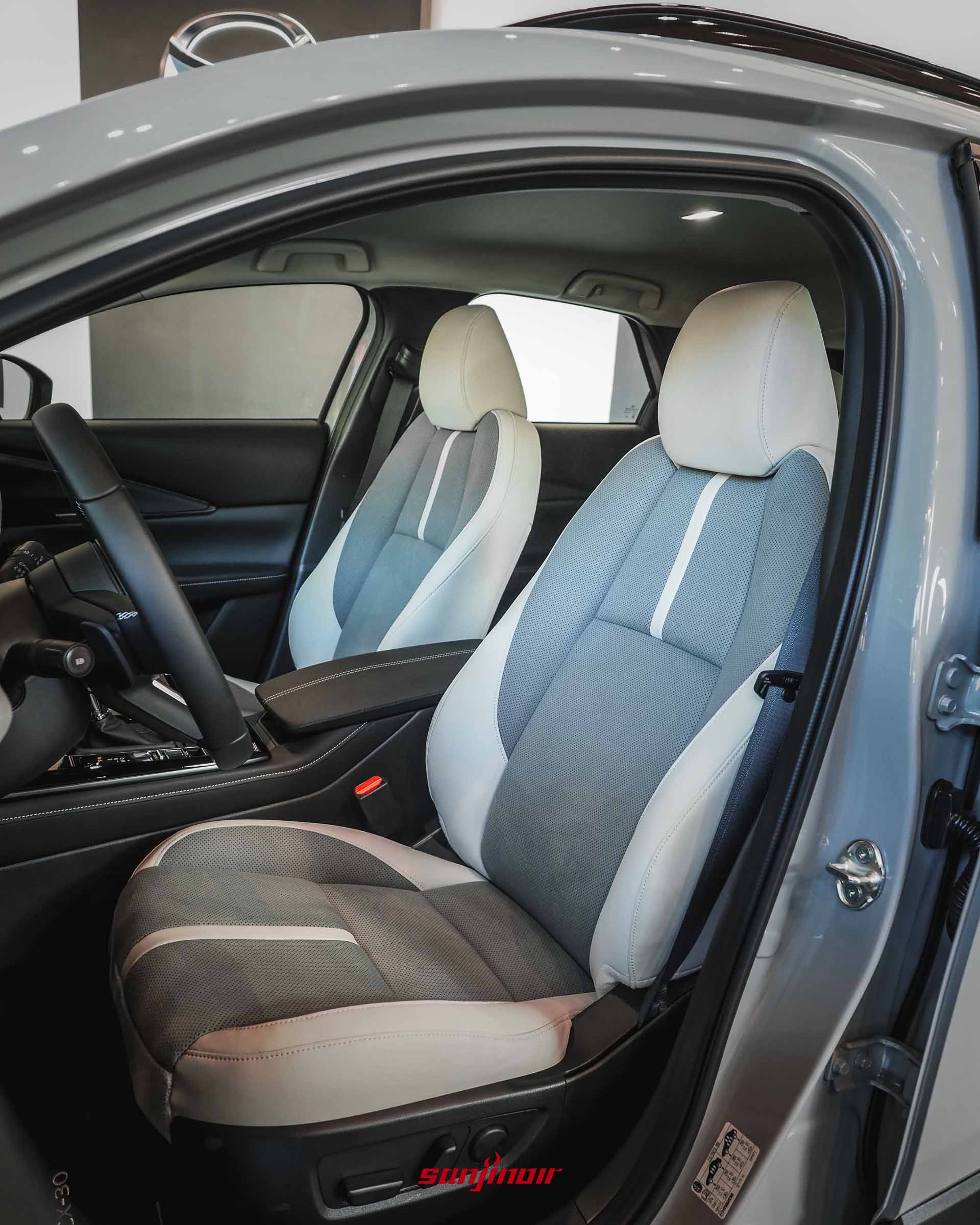 從車門外拍攝MAZDA CX-30 Air Edition的副駕駛座與駕駛座,展示灰白雙色調的Leganu麂皮與皮質雙色透氣座椅設計。