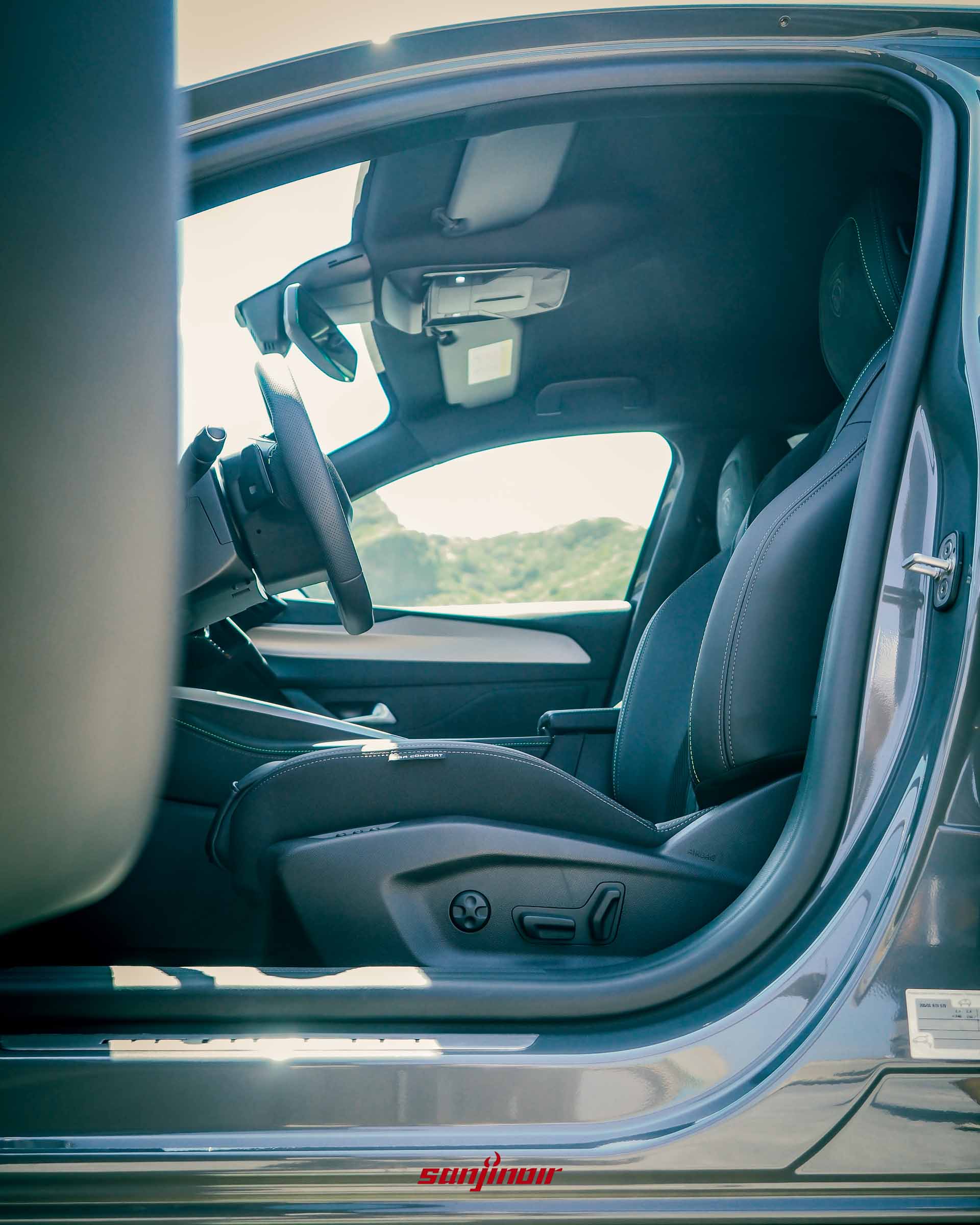 從打開的車門看向PEUGEOT 408駕駛座,展示具備按摩與加熱功能的跑車化座椅。