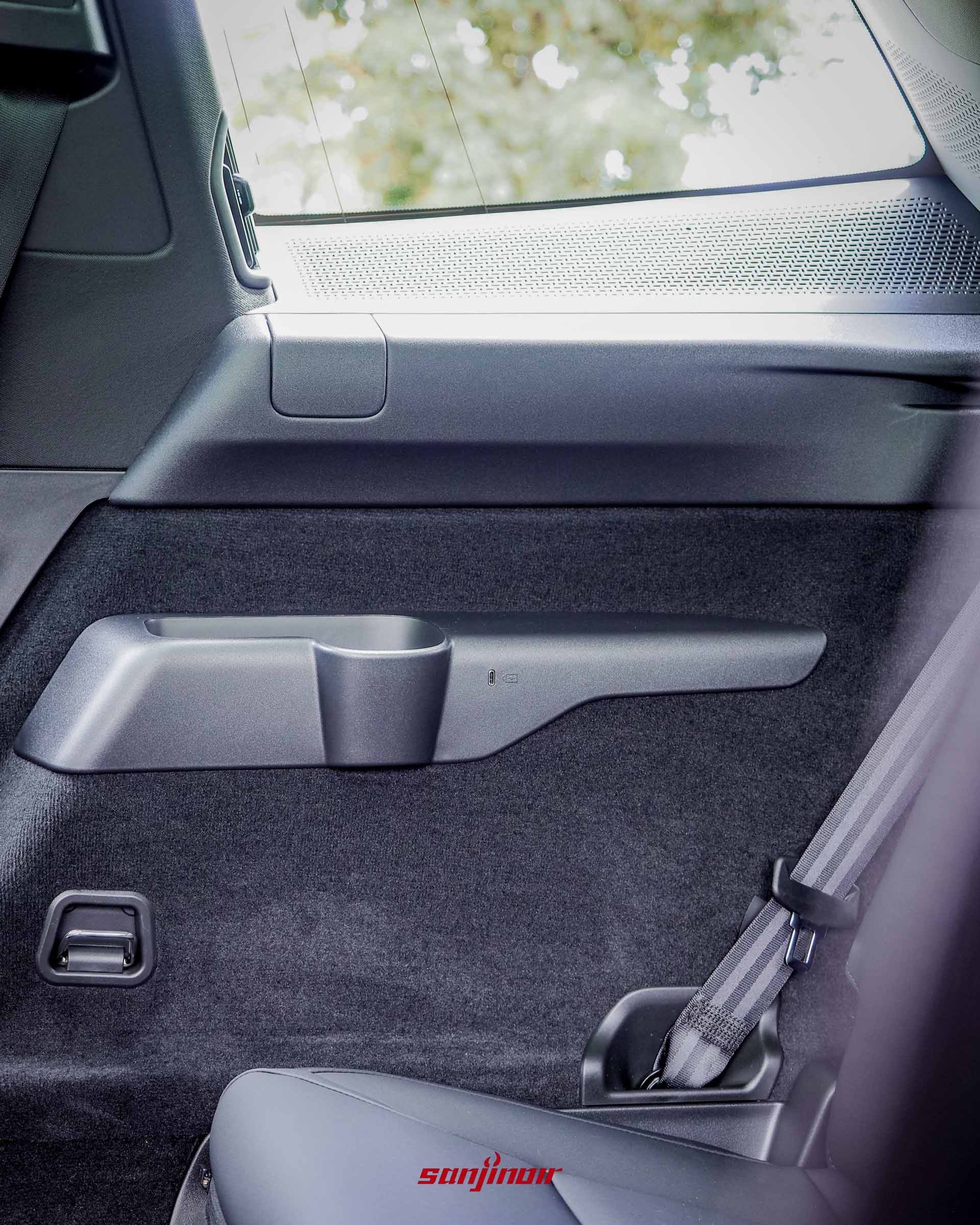 Volvo EX90第三排座位旁的側邊飾板特寫,配有一個置杯架與狹長的專屬小置物槽。