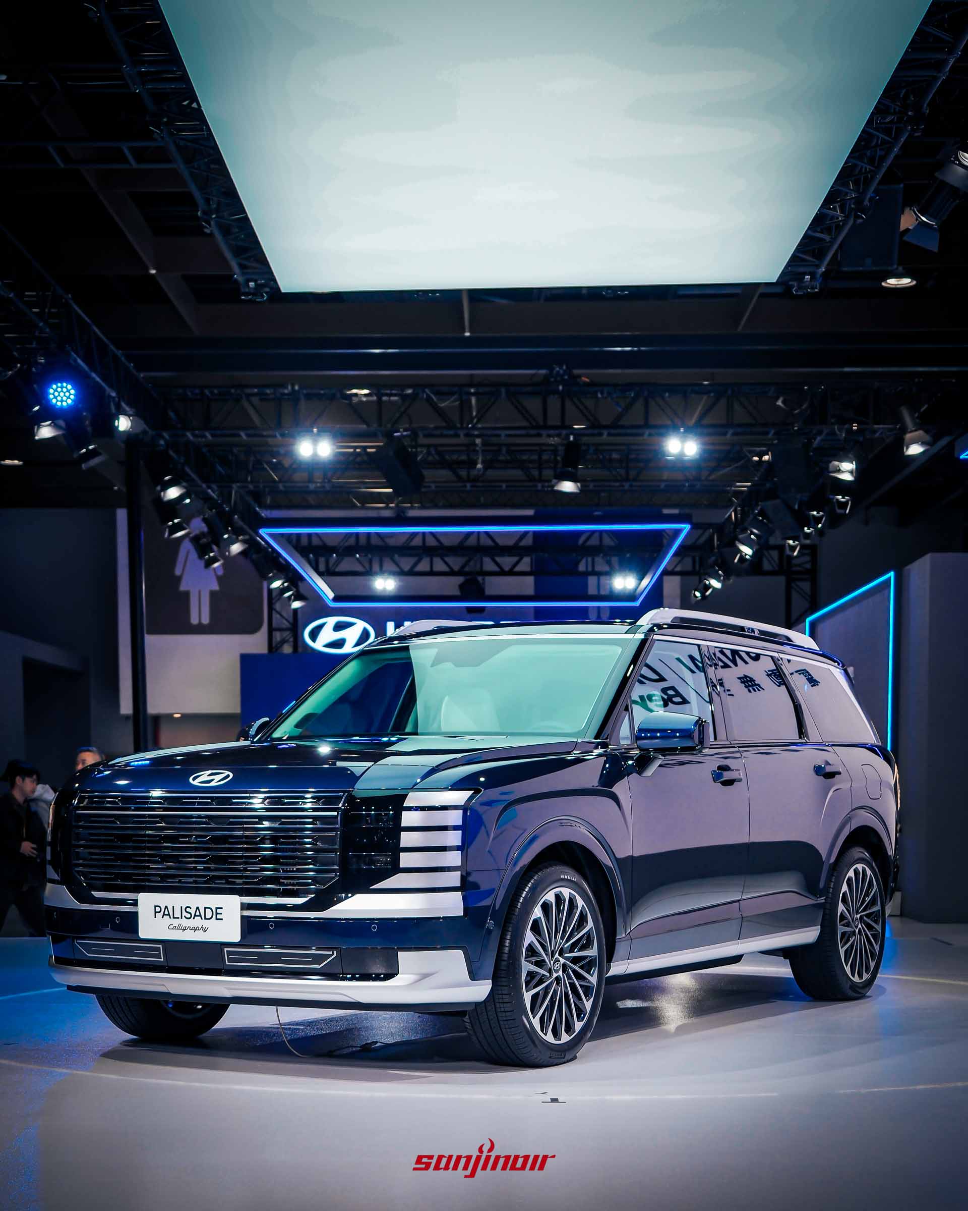 深藍色Hyundai Palisade Calligraphy旗艦休旅車於舞台上，上方有現代汽車的燈光裝飾。