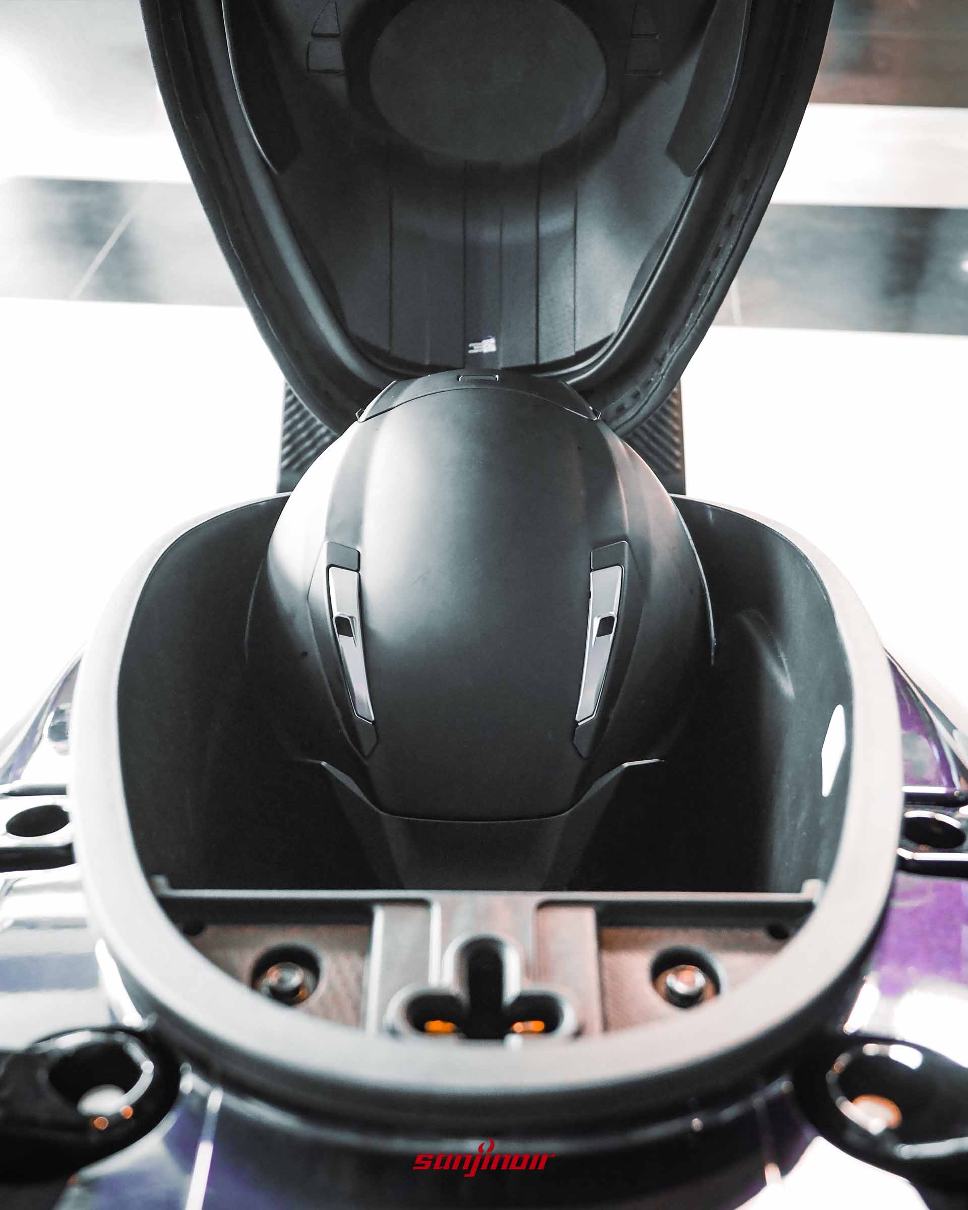 SYM Jet SL+ 坐墊下的置物空間，內部平放著一頂黑色全罩式安全帽。