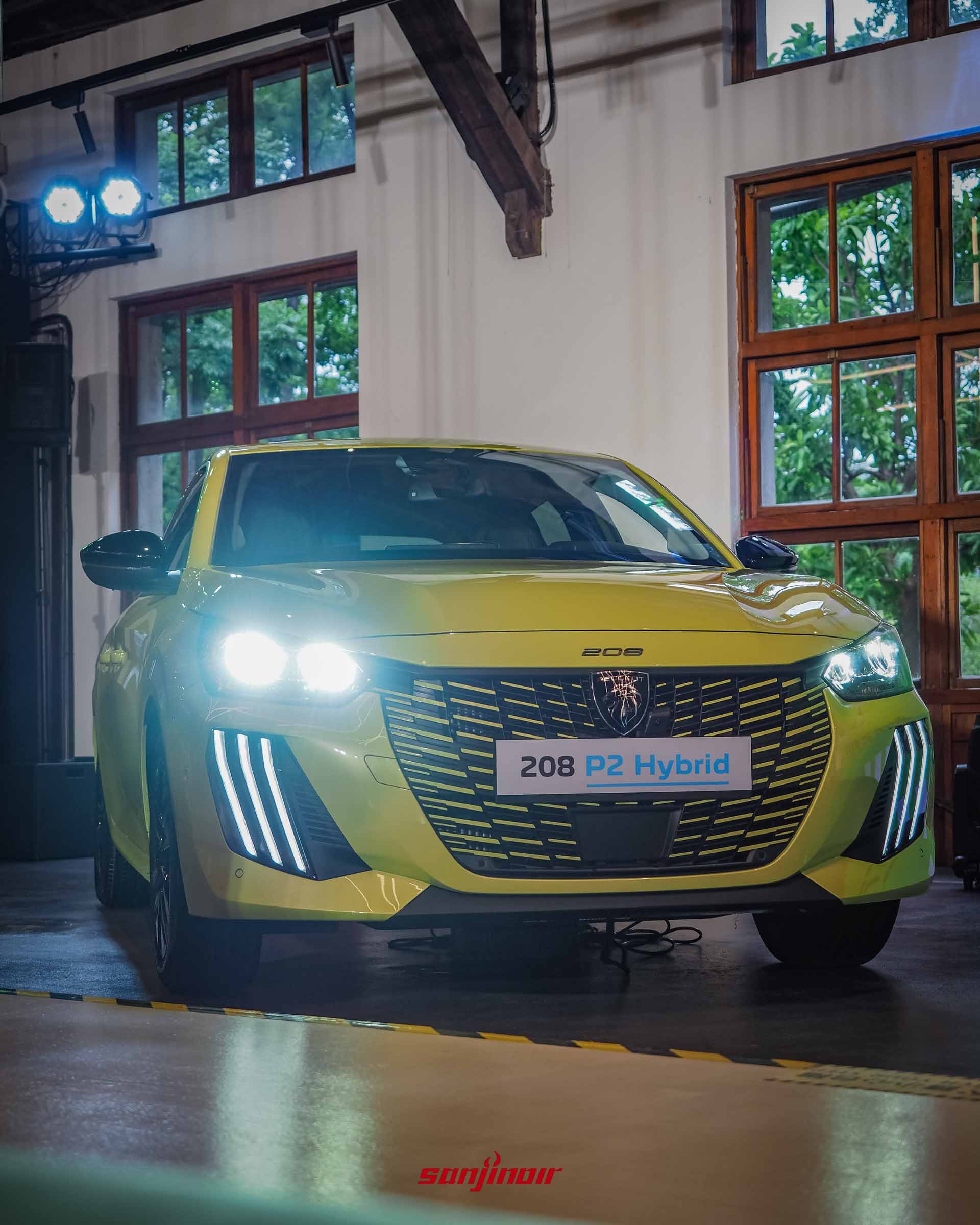 鮮黃色PEUGEOT 208 P2 Hybrid正面低角度特寫,LED大燈與日行燈耀眼點亮,展現極具侵略性的車頭氣勢。