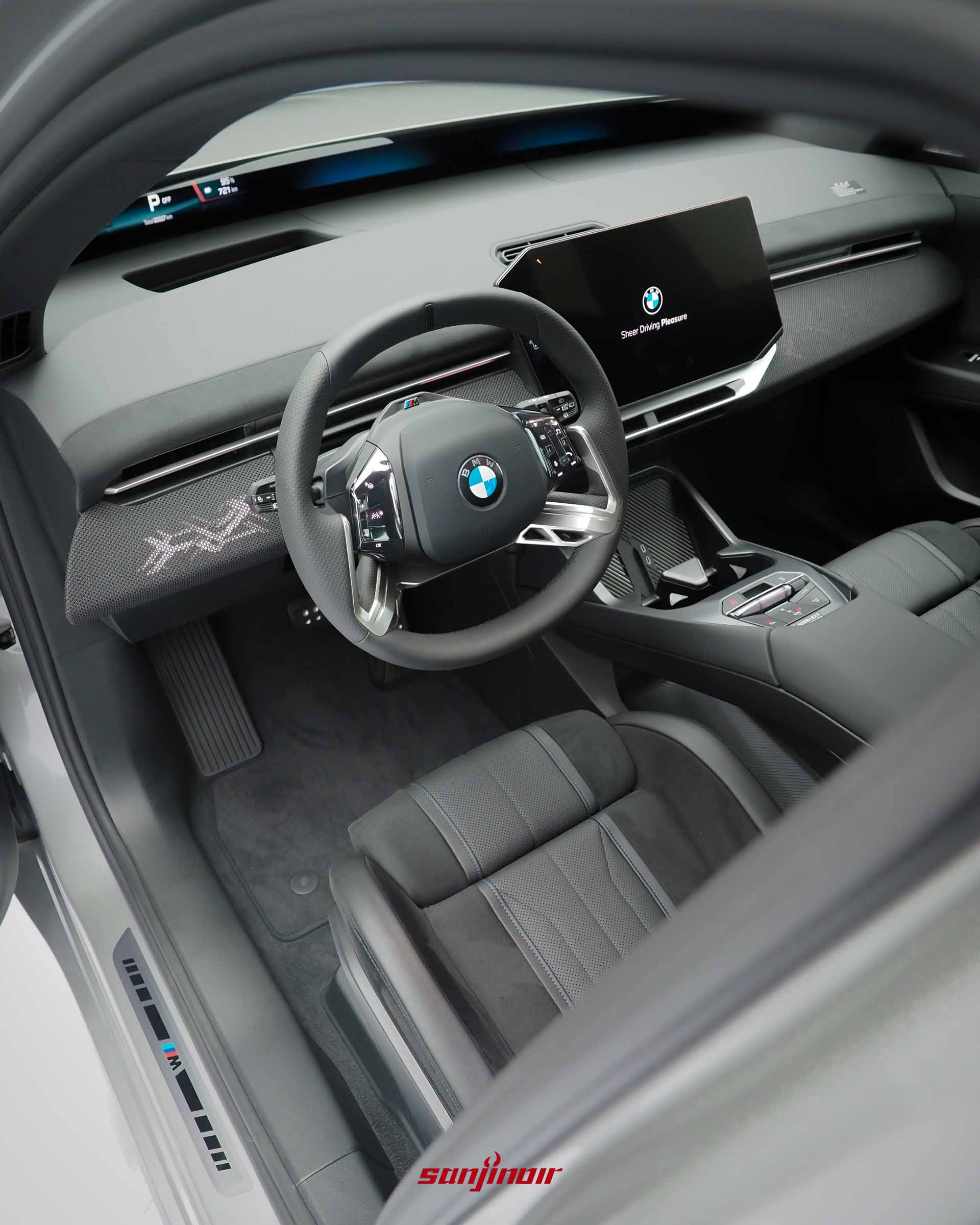 從駕駛座車門側看向車內中控台的整體俯瞰視角,具備全新造型方向盤與向駕駛傾斜的懸浮螢幕。