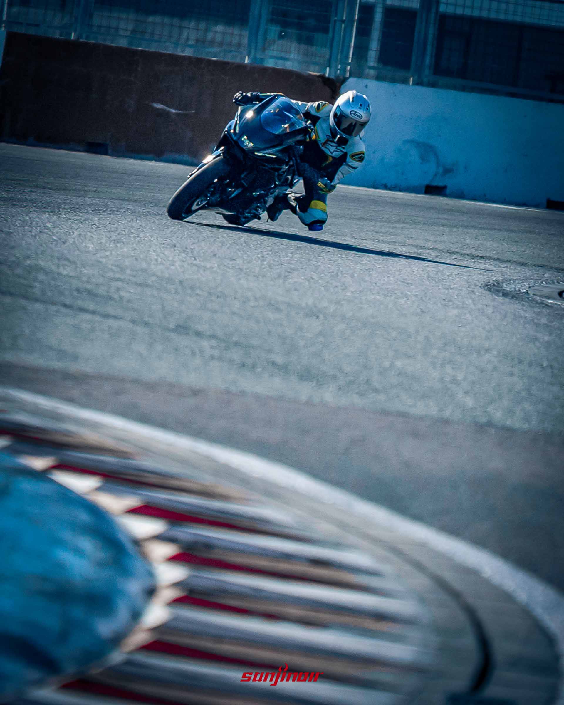 騎士駕駛黑色Yamaha YZF-R7在賽道上過彎的動態追焦照,騎士重心向內側轉移,車輛呈現大傾角。