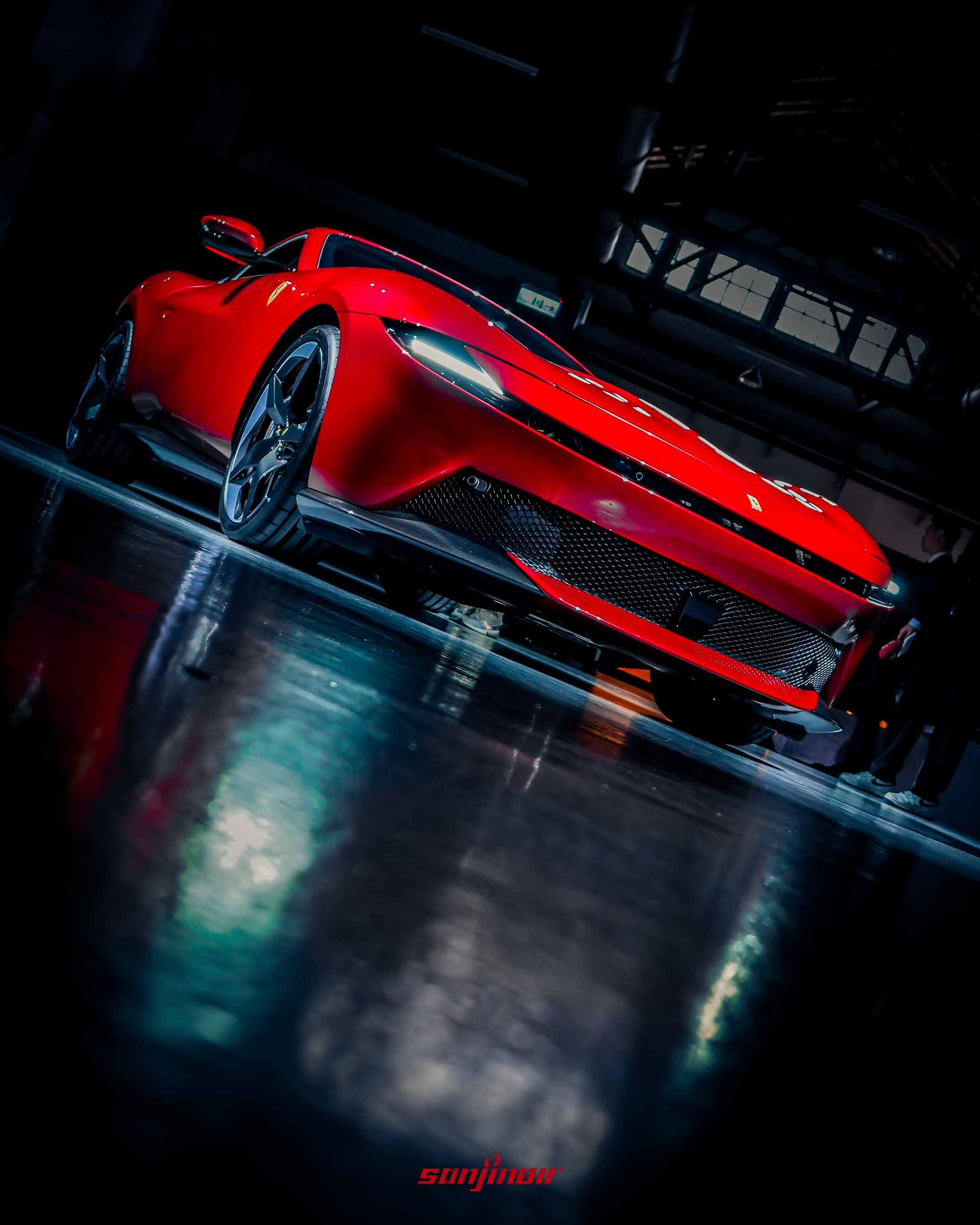 紅色Ferrari Amalfi車頭低角度特寫，地面倒影映襯出車頭銳利線條與深色網狀進氣壩。