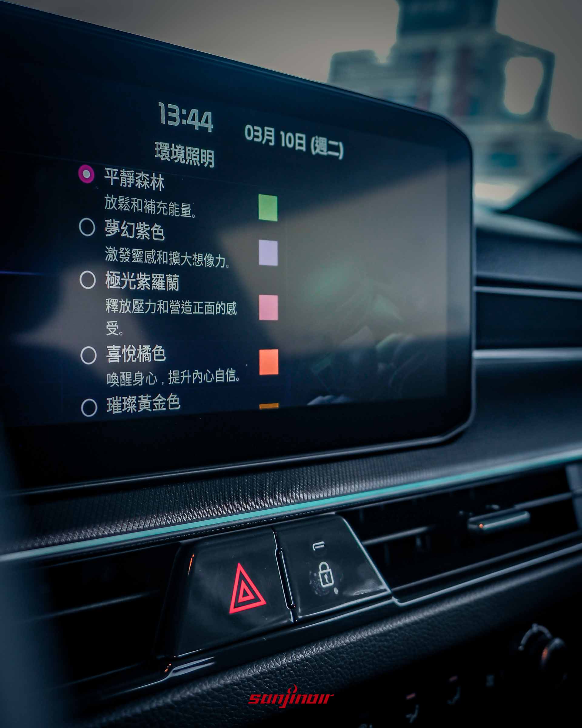 近距離特寫 2026 Kia Stonic 的中控觸控螢幕,顯示「環境照明」設定選單,包含「平靜森林」、「夢幻紫色」等多種色彩選項,下方可見三角形警示燈與車門鎖實體按鍵。