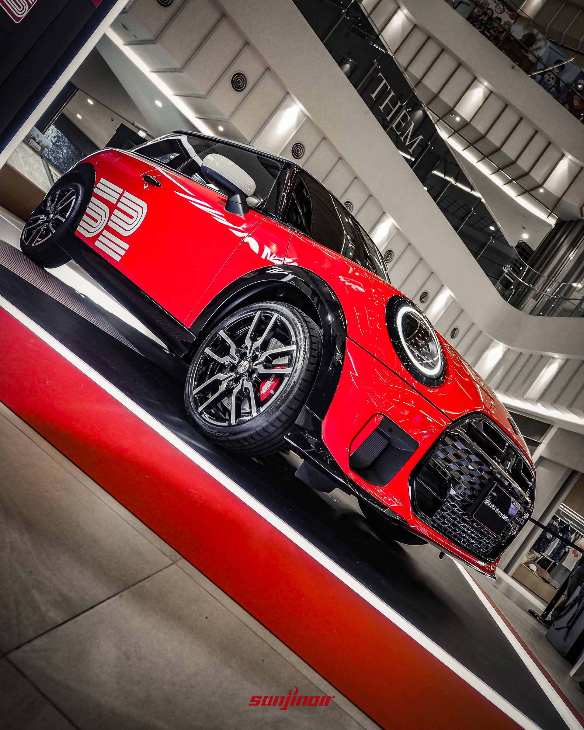 從低角度仰拍停放在展示台上的MINI 1965 Victory Edition,凸顯霸氣的車頭與流線的車身輪廓。