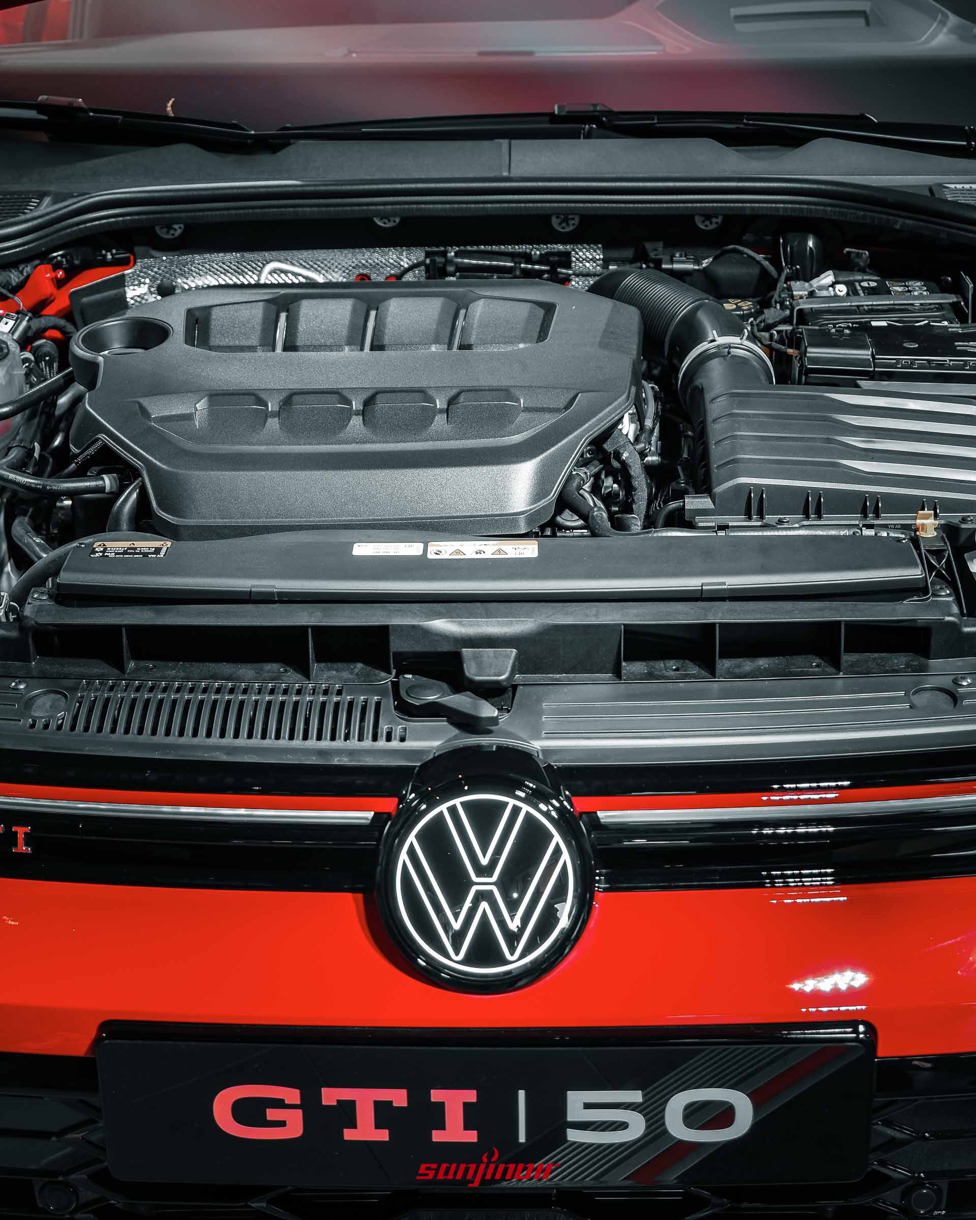 Golf GTI EDITION 50引擎室與車頭特寫，展示2.0升引擎飾蓋，以及車頭水箱護罩上發光的福斯廠徽與LED定位燈。