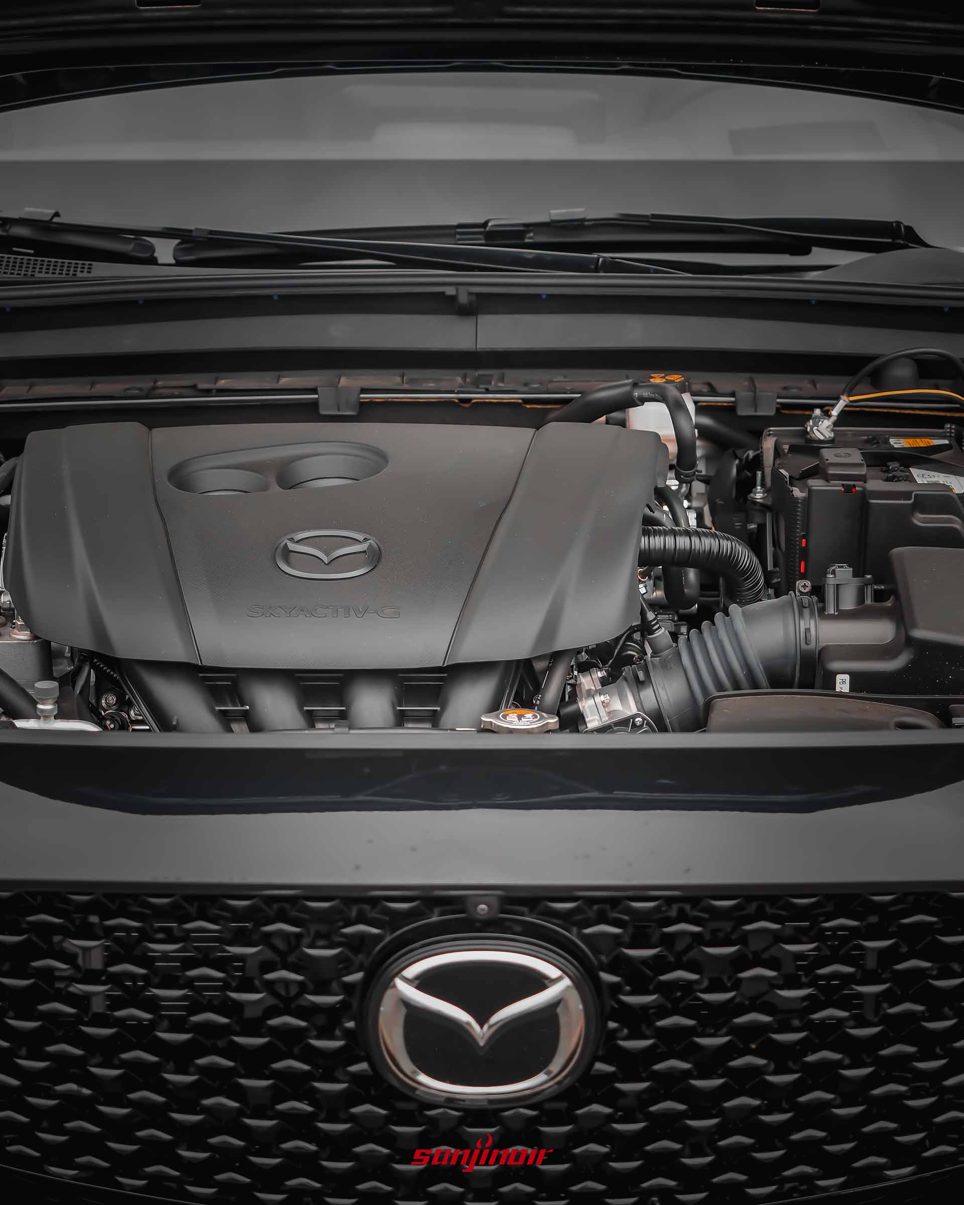 MAZDA CX-30引擎室特寫,展示印有MAZDA廠徽與SKYACTIV-G字樣的黑色引擎飾蓋。