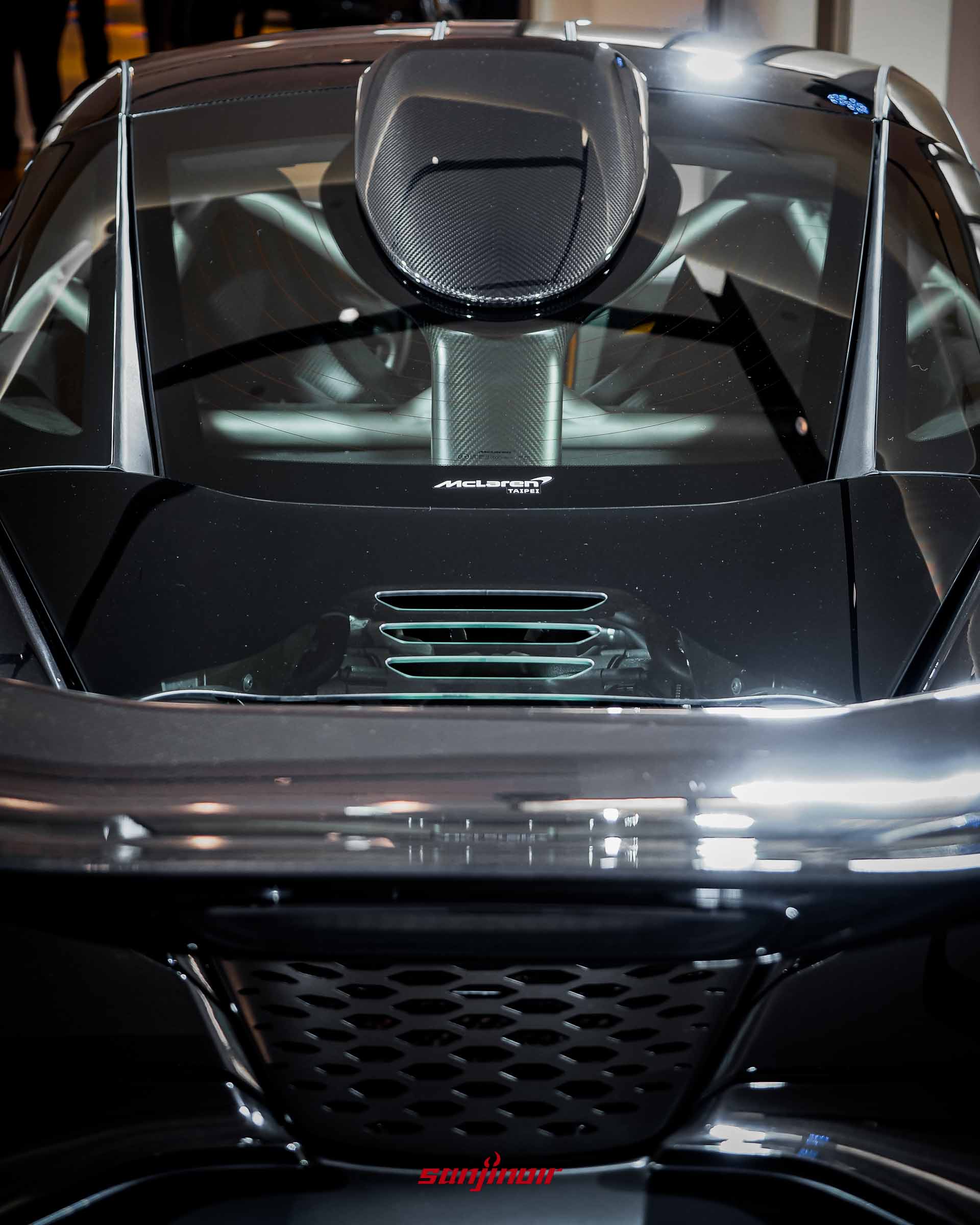 McLaren 750S Le Mans車頂與後引擎蓋特寫,展示流線型的碳纖維車頂進氣口,以及下方帶有青綠色邊緣的引擎散熱鰭片。