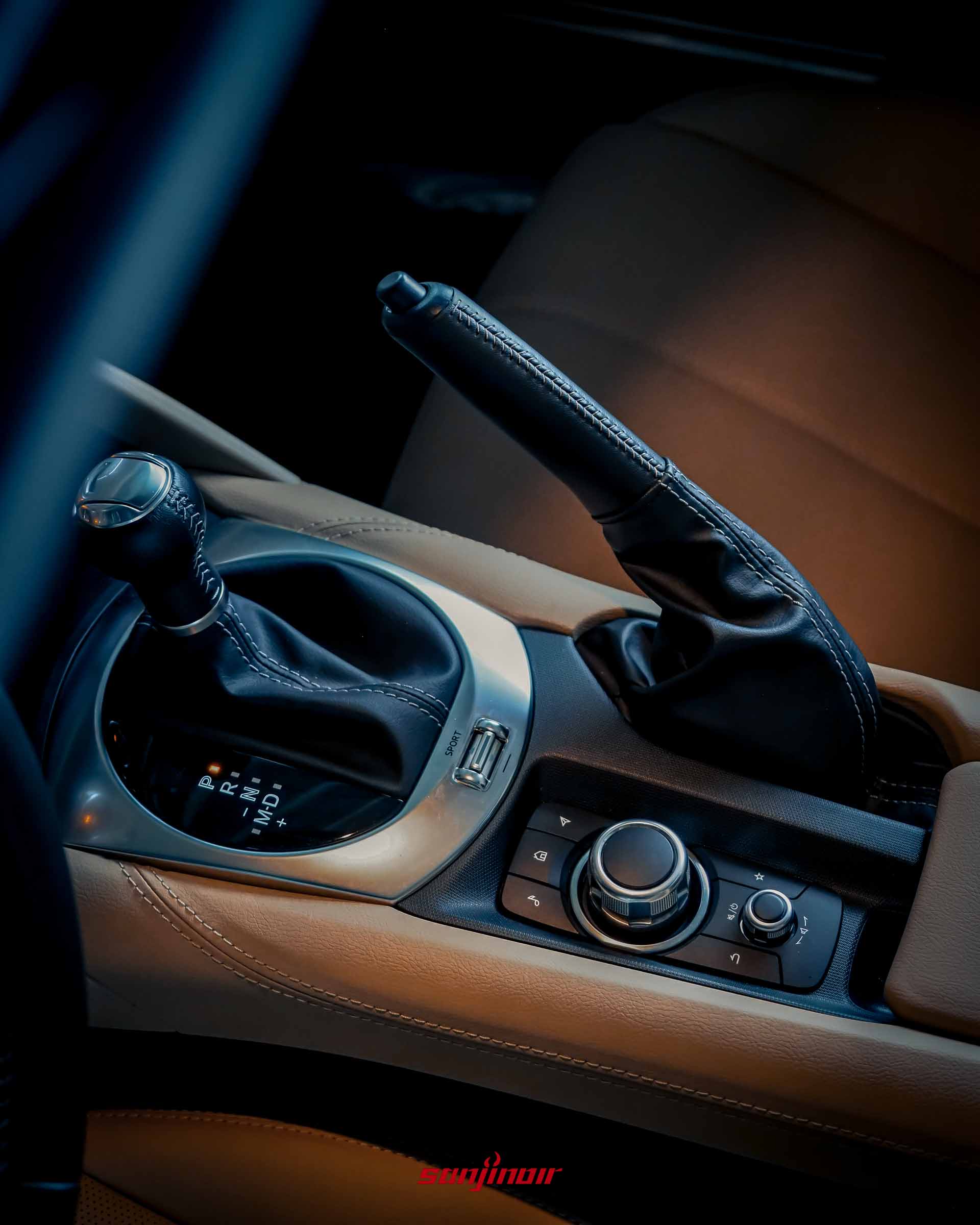 Mazda MX-5 RF 中央鞍座特寫,展示自排排檔桿、多媒體控制旋鈕與傳統手煞車拉柄。