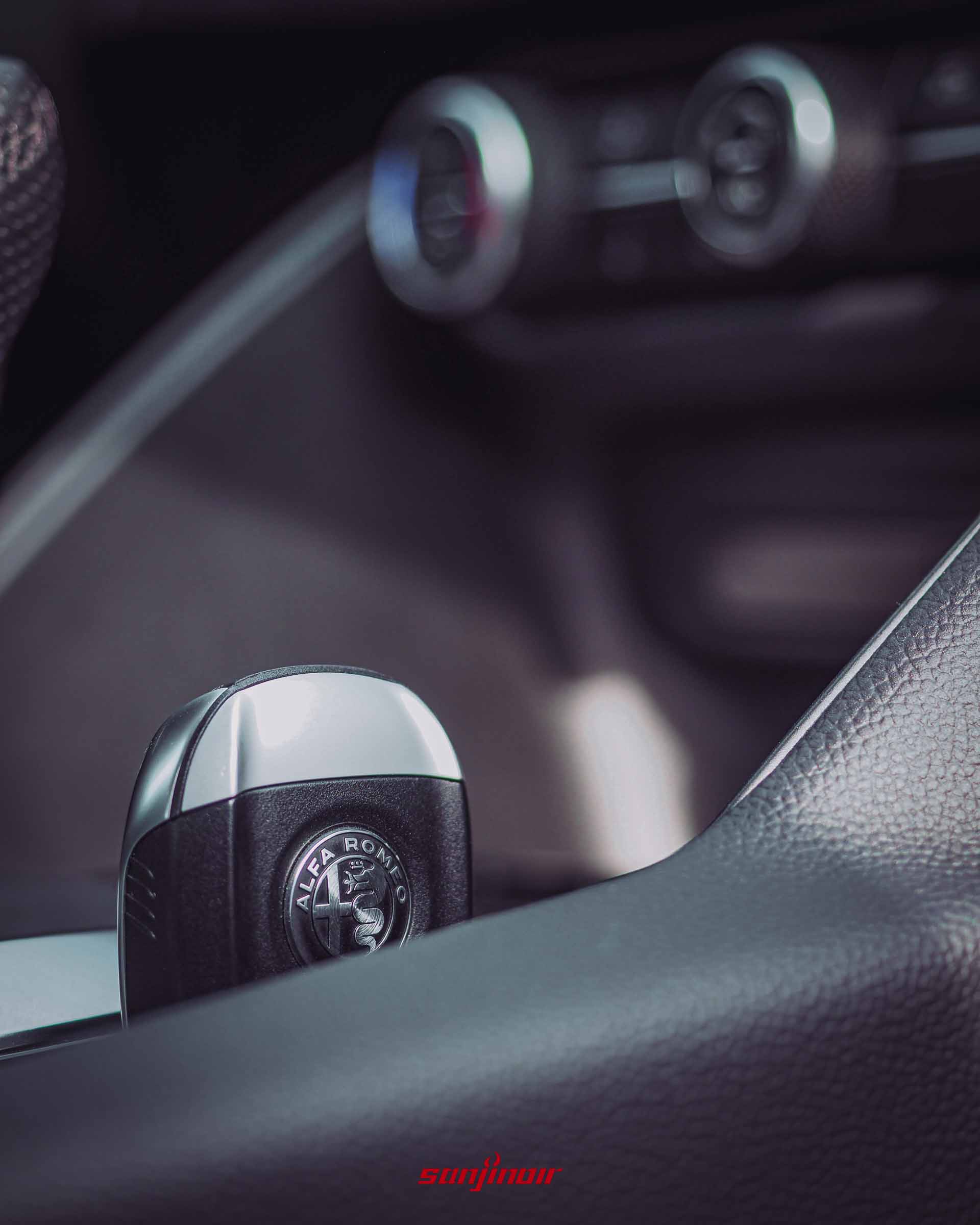 Alfa Romeo Giulia Sprint車鑰匙特寫,放置於中央鞍座,表面刻有精緻廠徽。