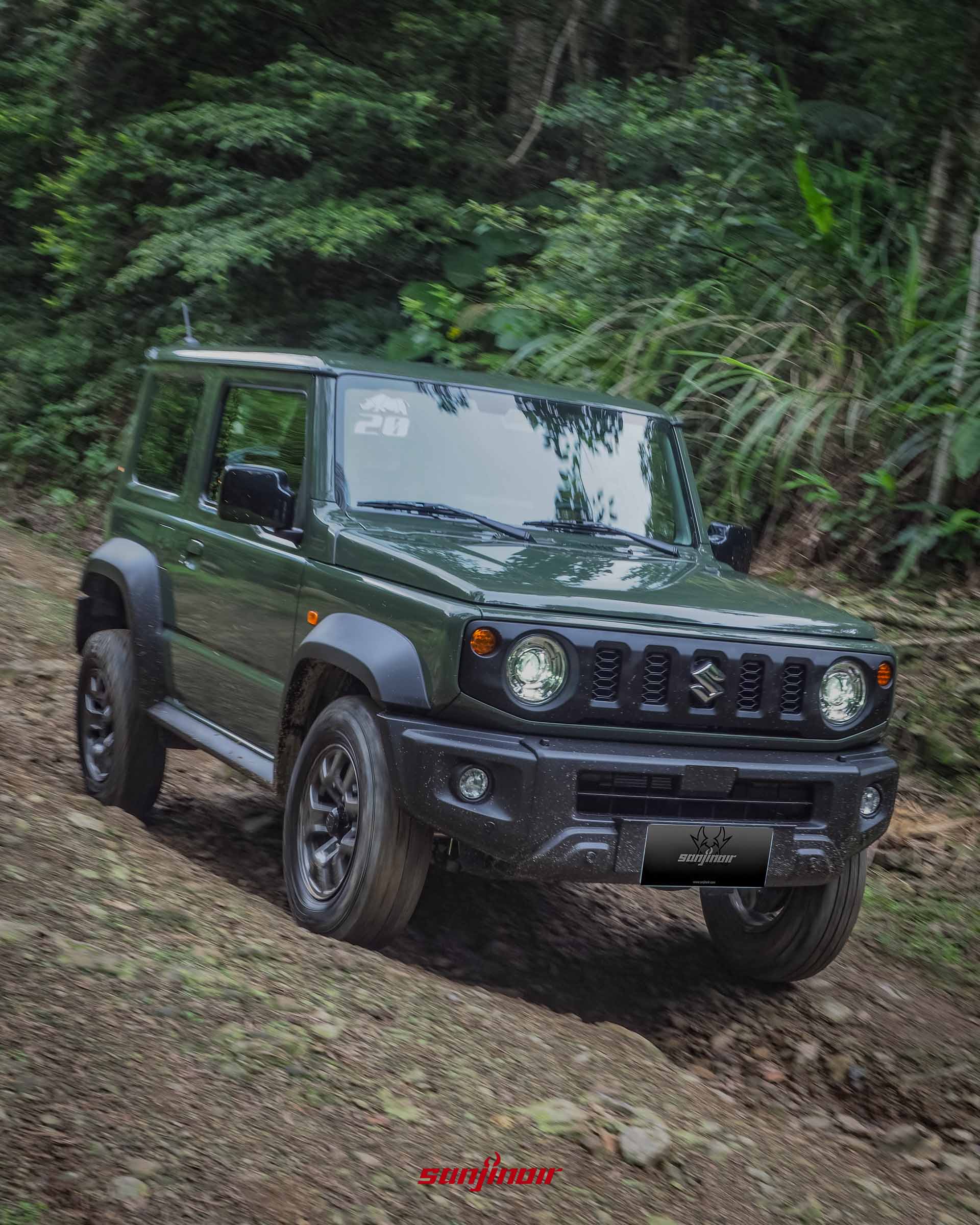 軍綠色SUZUKI Jimny正在充滿碎石的陡峭山道上進行越野下坡的照片。