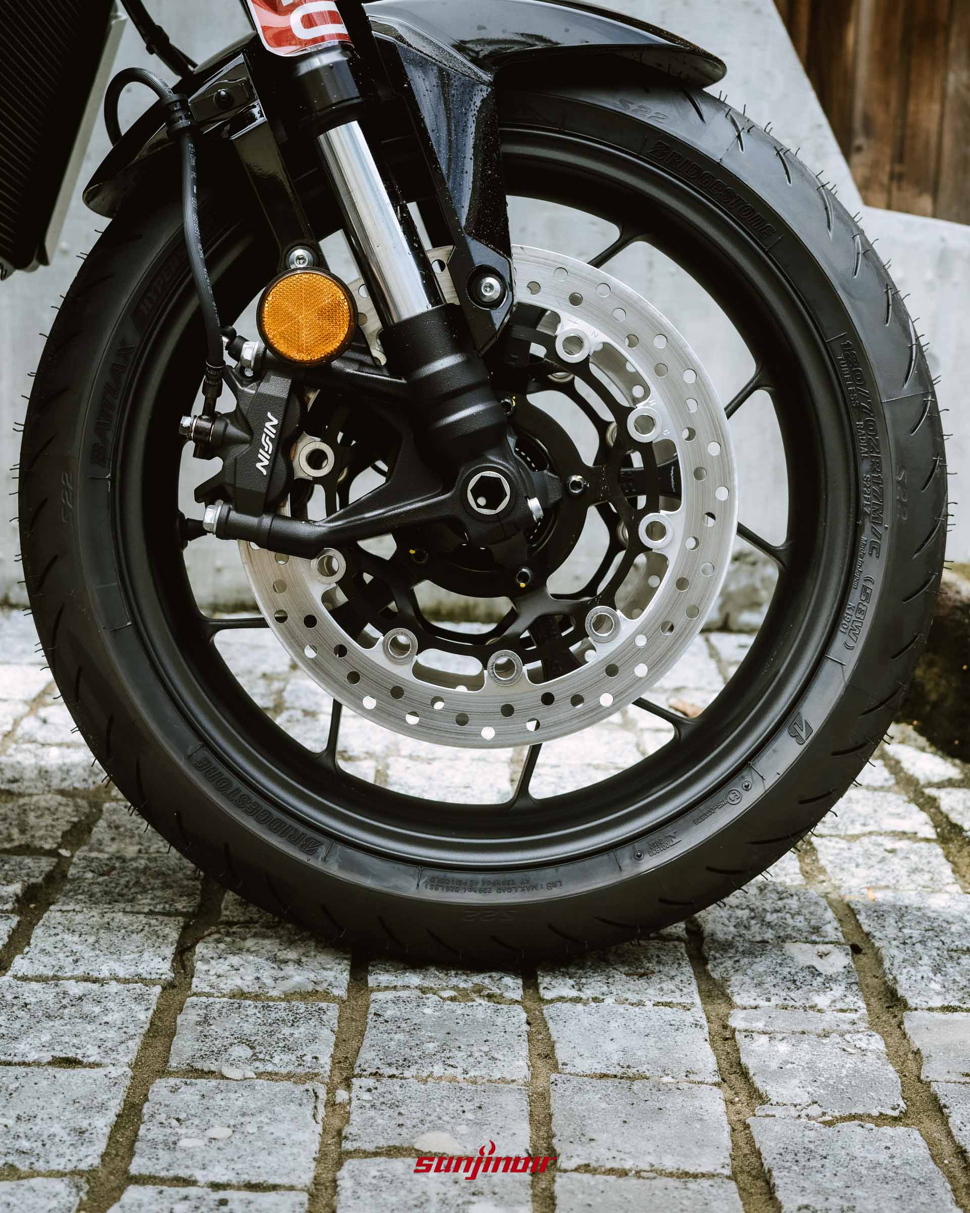 Honda CB1000F前輪特寫照片,展示黑色輪框、煞車通風碟盤、Nissin對向卡鉗與倒立式前叉下座。