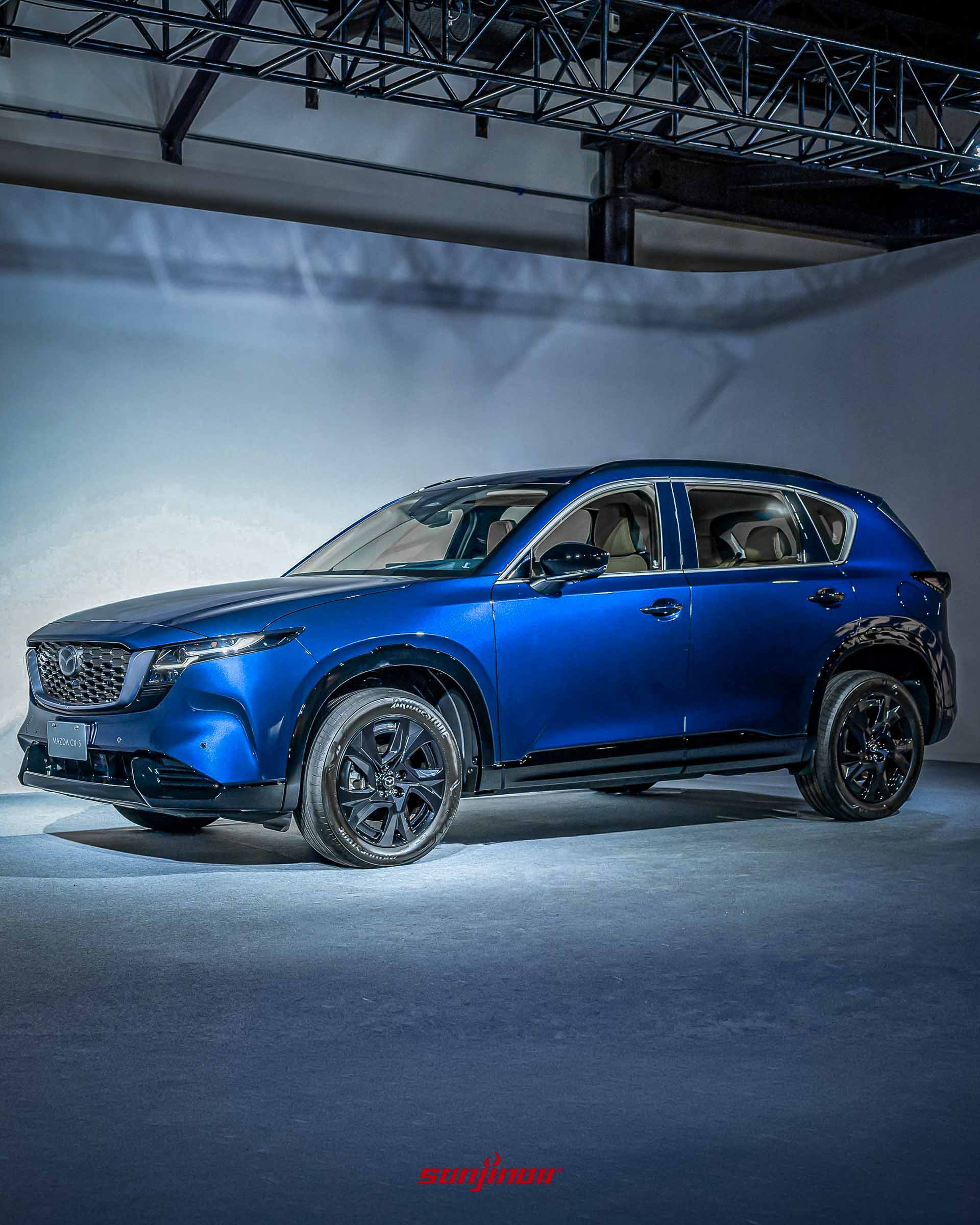 湛海藍車色的MAZDA CX-5側前方面貌，展示於攝影棚內，呈現深藍色的飽和光影反射。