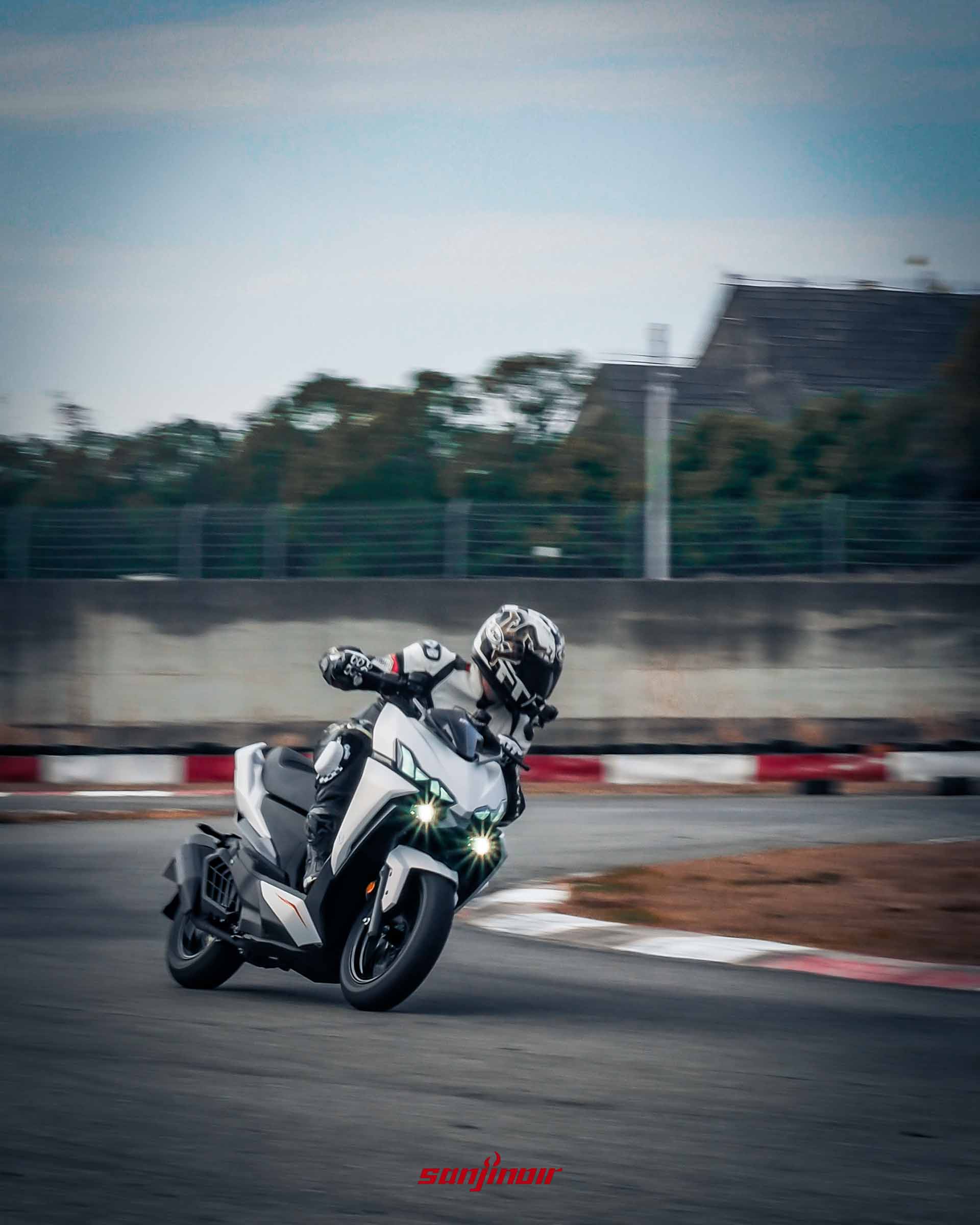 駕駛白色2026年式樣SYM DRGBT在賽道彎道中壓車過彎。