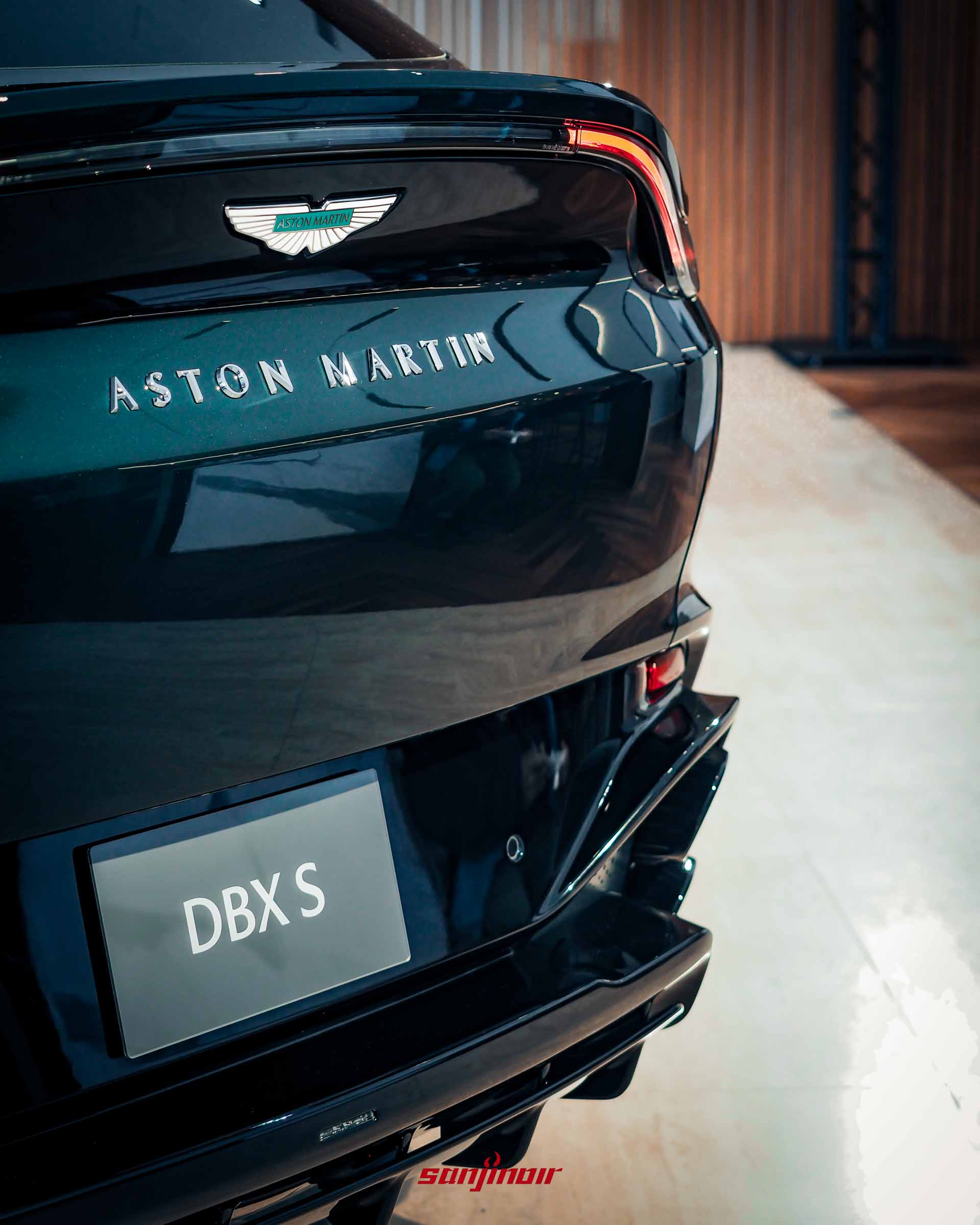 Aston Martin DBX S車尾特寫，展示尾門上的Aston Martin飛翼廠徽與金屬字樣，以及下方帶有DBX S字樣的車牌與立體的競技化下擾流設計。