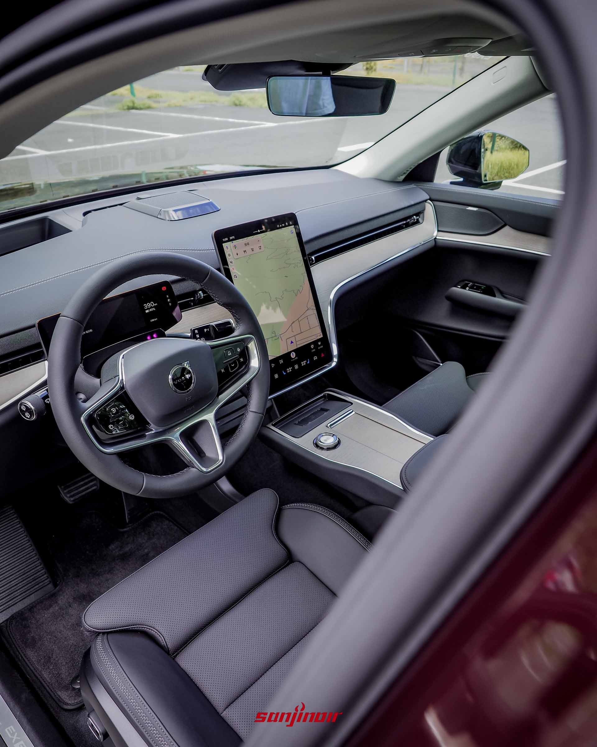 Volvo EX90的前座中控台全景,包含多功能方向盤、小尺寸數位儀表、14.5吋中央直立式觸控螢幕與淺色天然木紋飾板。
