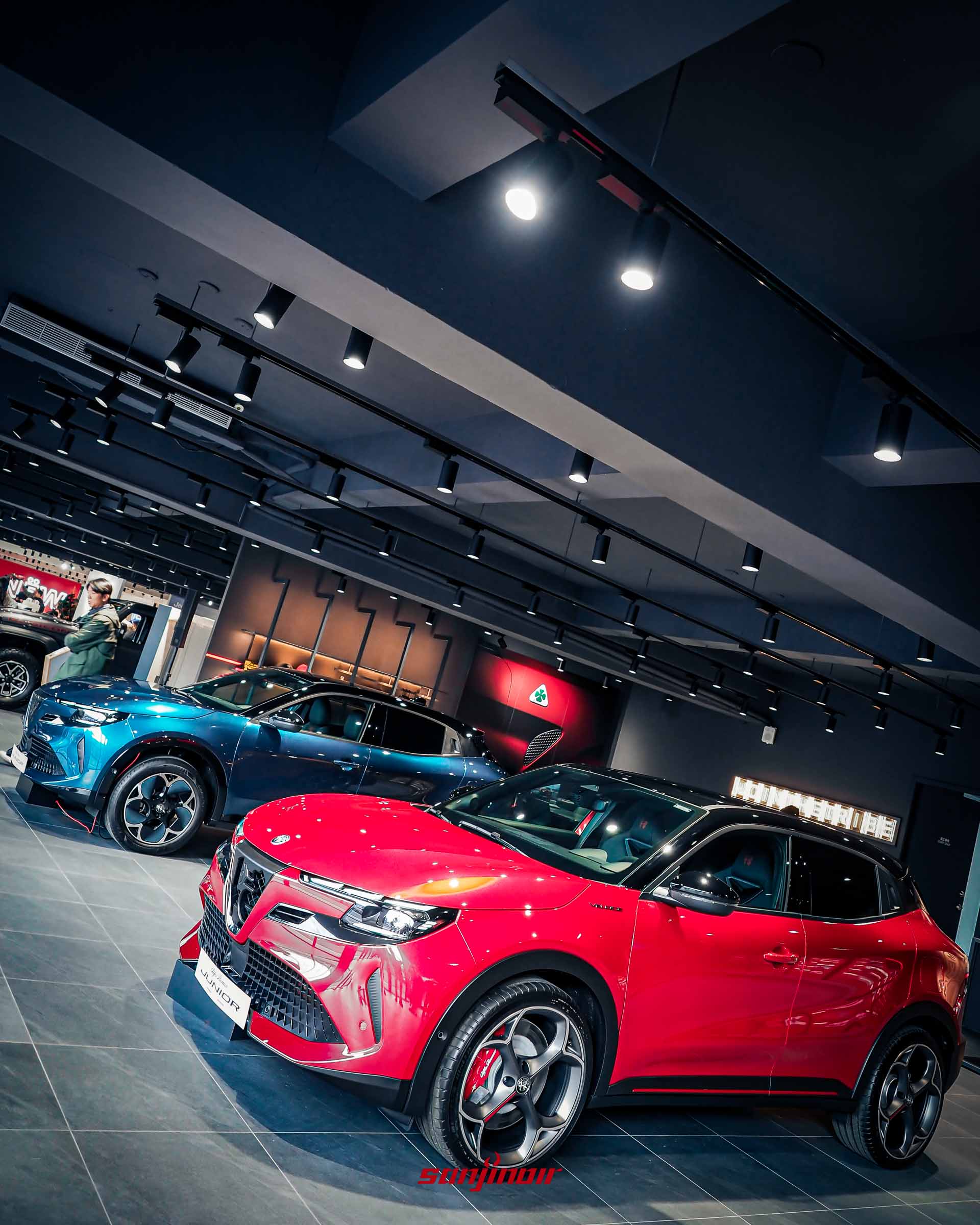 2026台北車展前哨站，展間內停放一紅一藍兩輛Alfa Romeo Junior，由高角度拍攝。