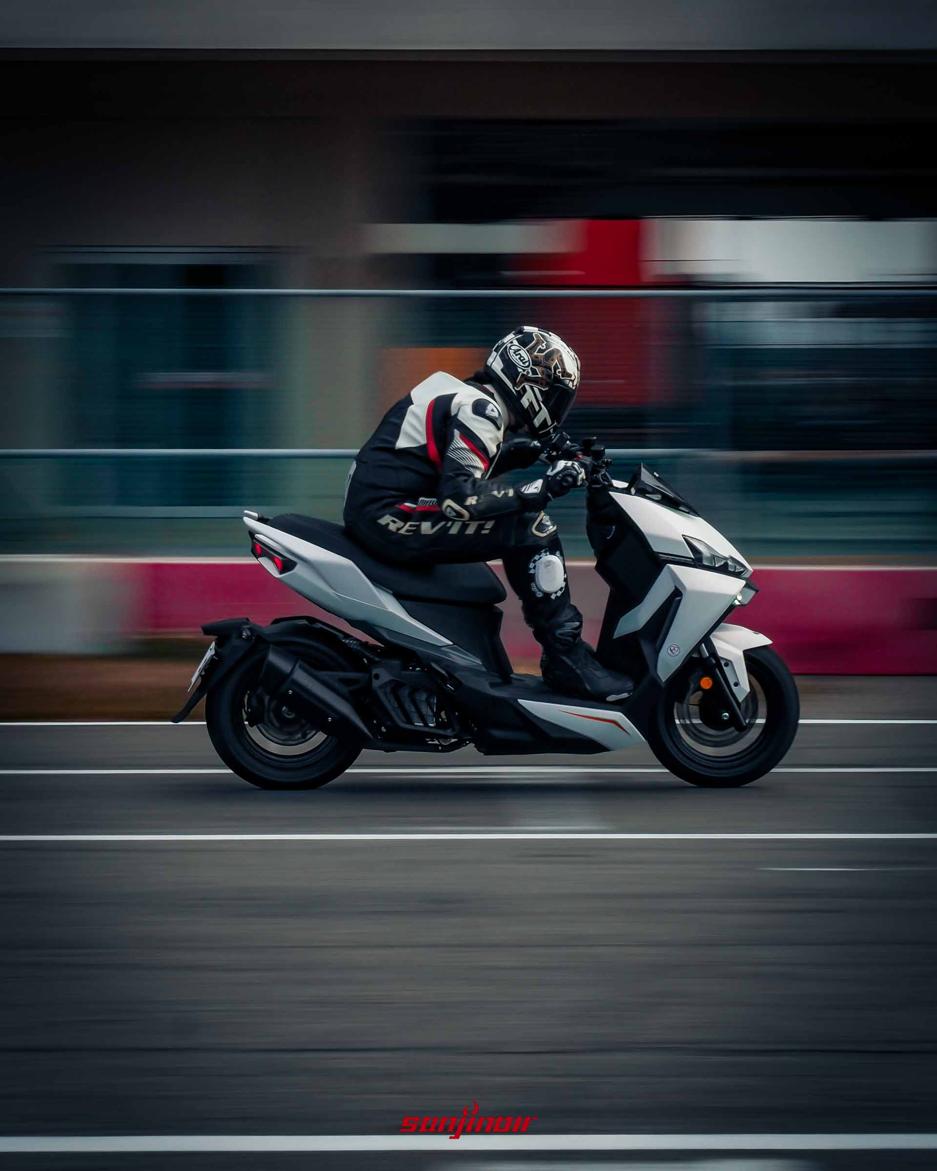 騎士駕駛白色2026年式樣SYM DRGBT在賽道直線路段高速行駛的追焦照。