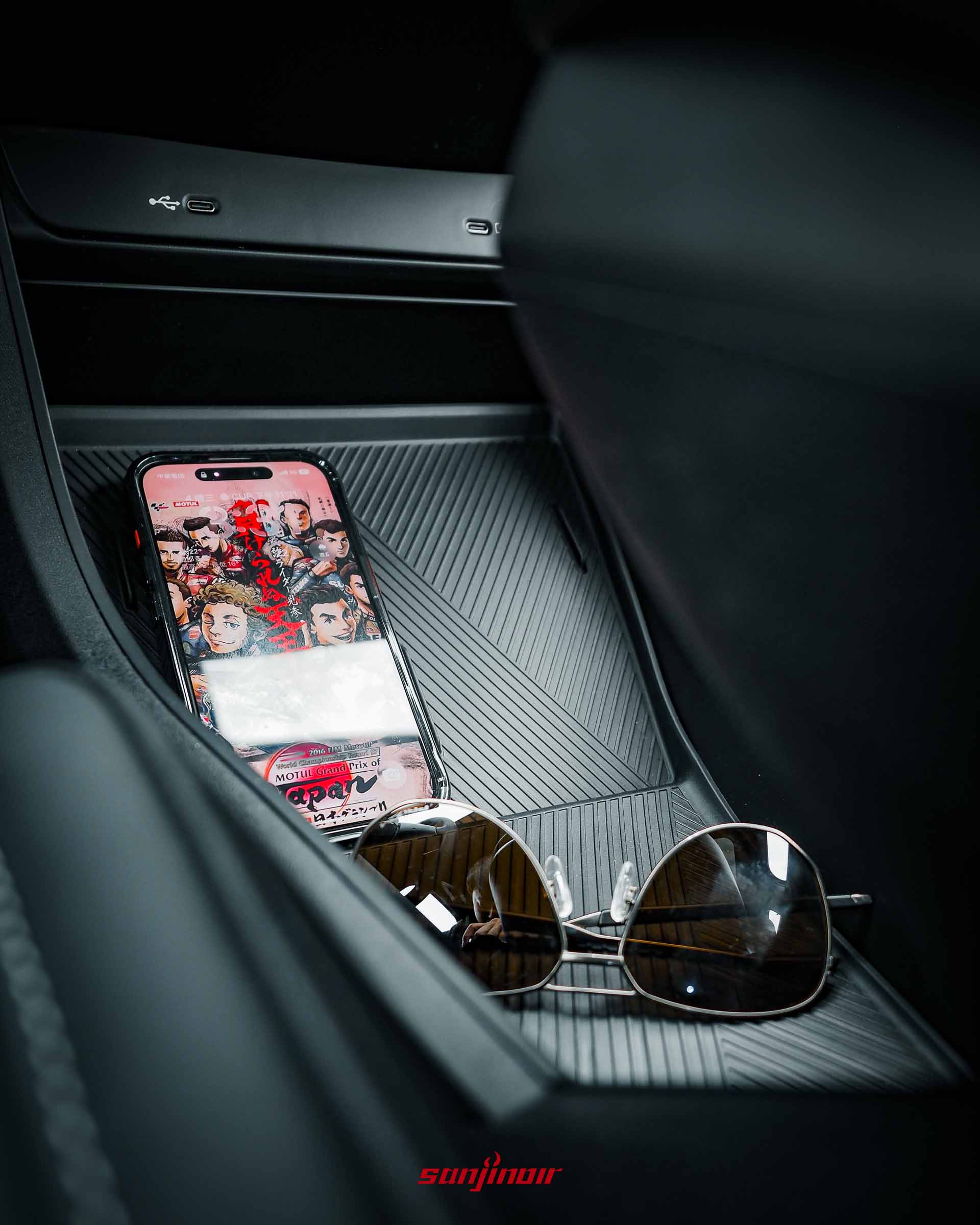 Foxtron Bria Emerge中央鞍座的無線充電板，上方放有手機與太陽眼鏡。