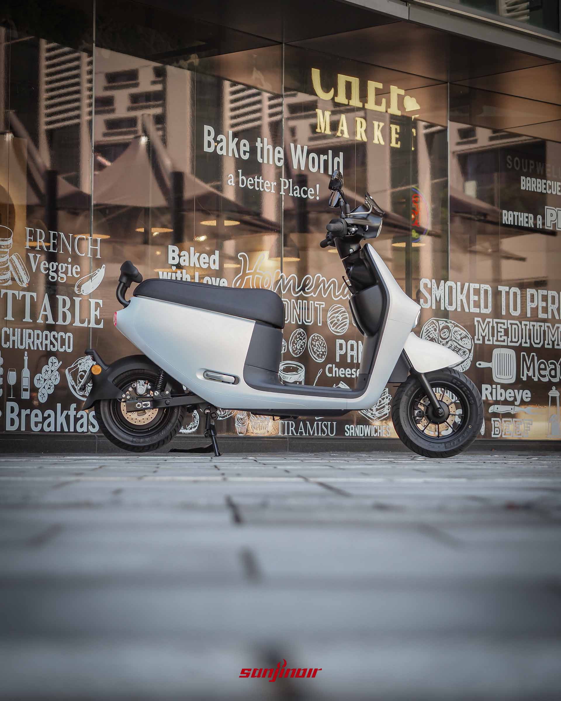 Gogoro Luna右側視角照片,背景為寫著DELIMARKET等字樣的玻璃櫥窗。