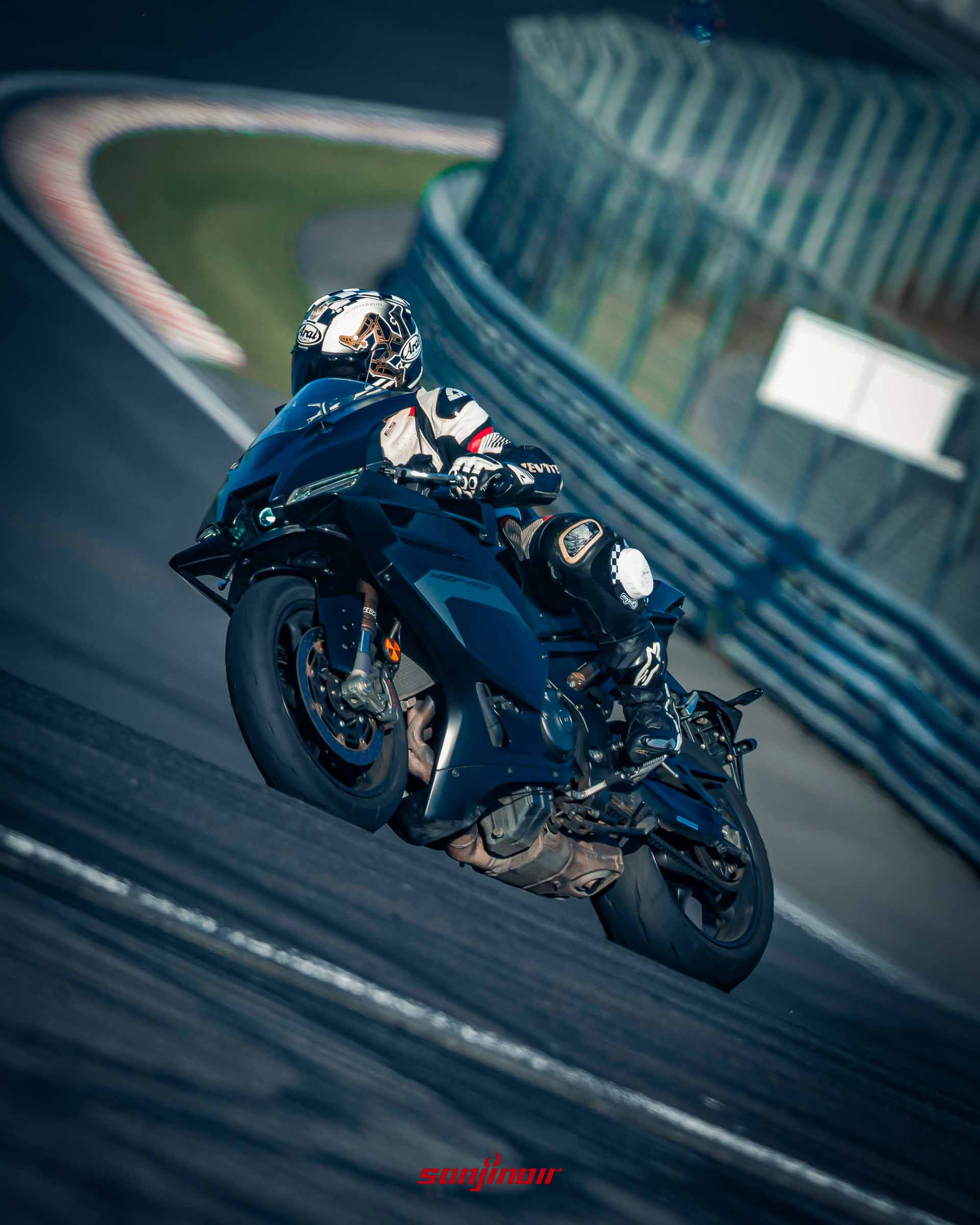 動態追焦攝影,一名騎士駕駛黑色Yamaha YZF-R9在賽道上向左傾倒過彎,車頭兩側的定風翼清晰可見。