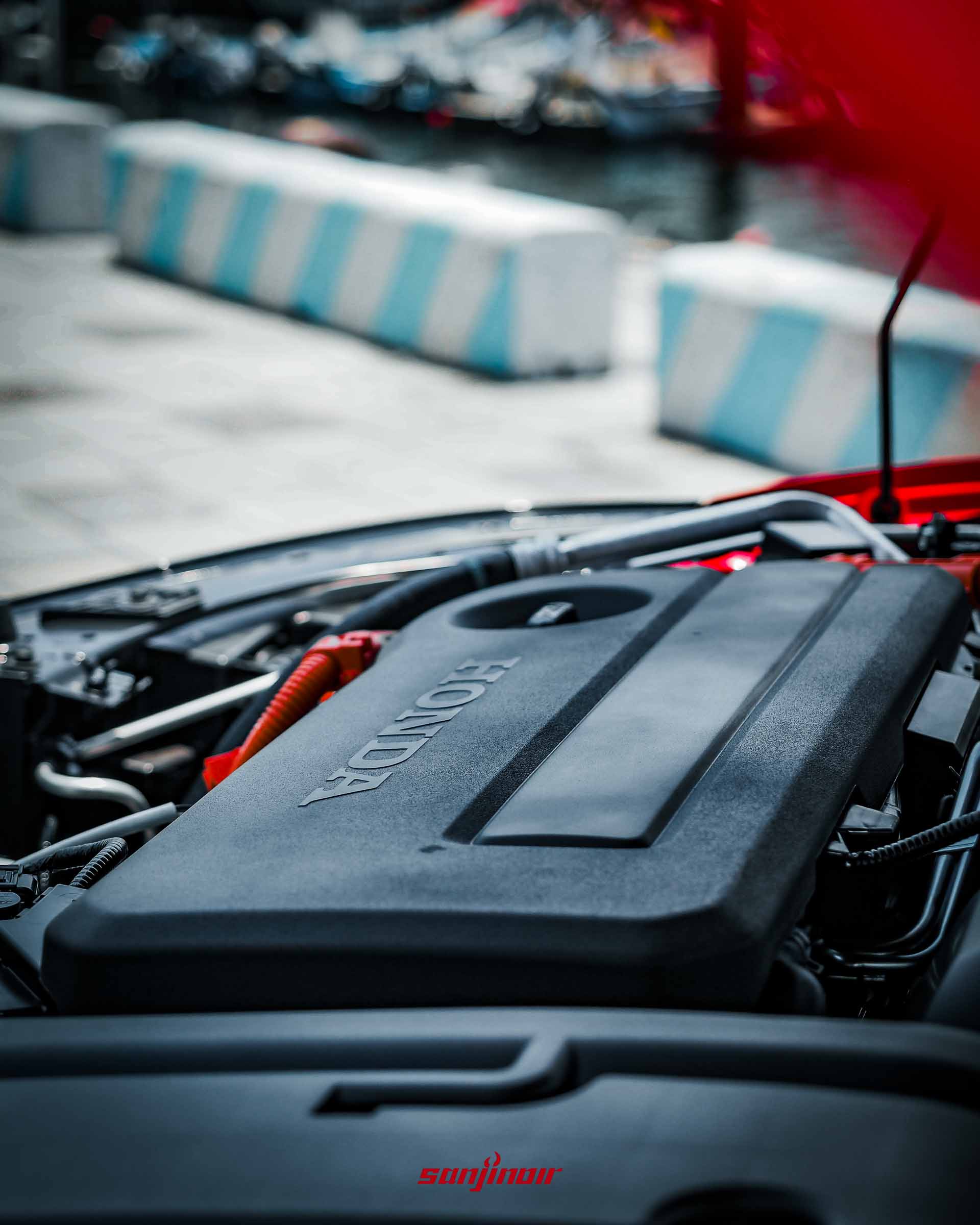 特寫HONDA Prelude引擎室內部,可見印有HONDA字樣的黑色引擎飾蓋與代表油電系統的橘色高壓線束。