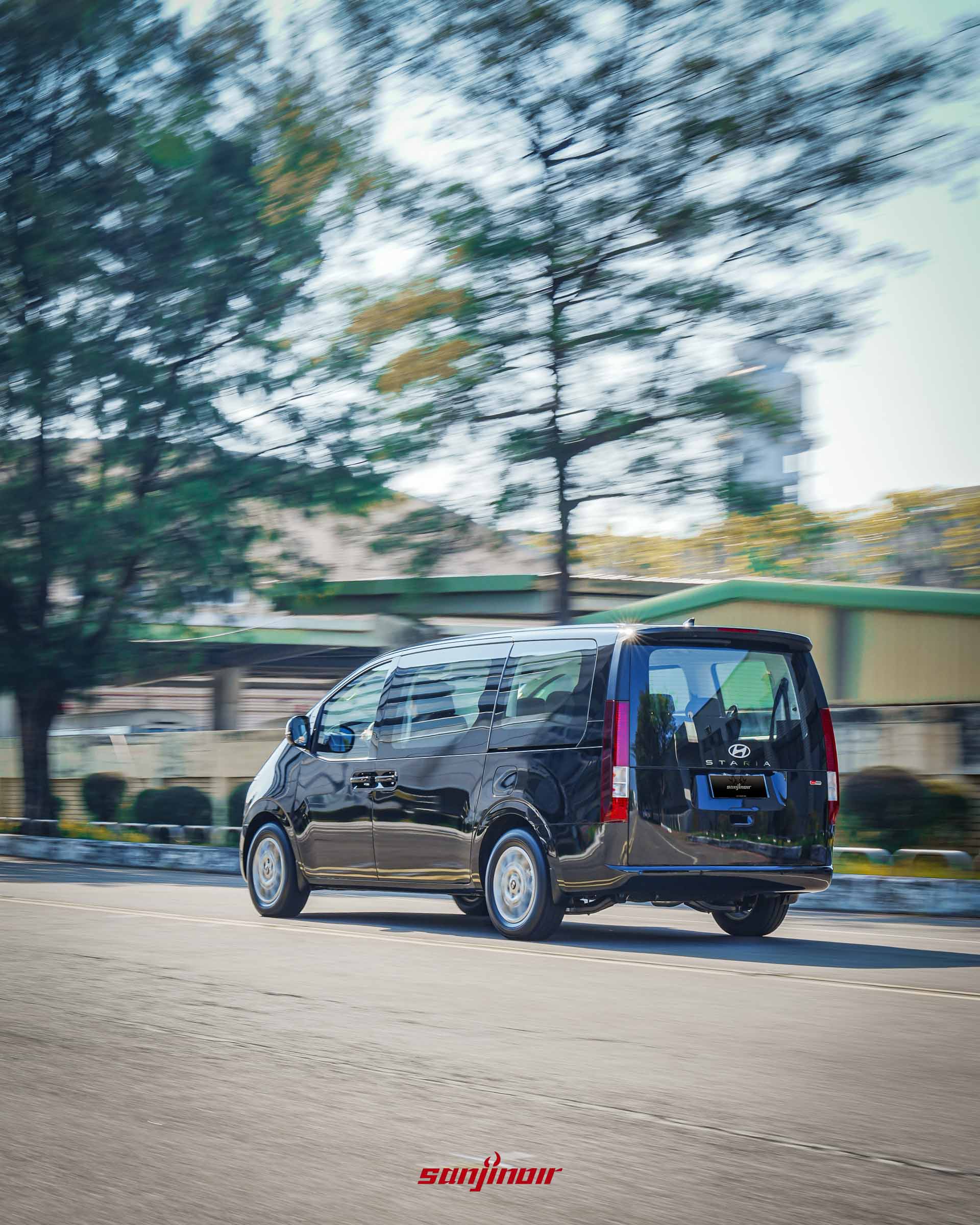 黑色 Hyundai Staria 在道路上行駛的動態追焦攝影,從右後側視角展現其行路時的平穩與直立尾燈的辨識度。