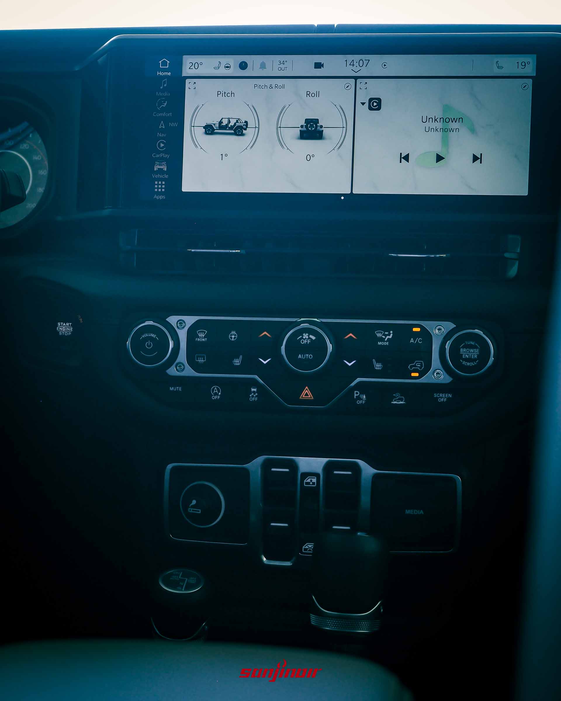 Jeep Wrangler Sahara 的中控台特寫,12.3 吋螢幕顯示車輛傾角資訊(Pitch & Roll),下方有雙區恆溫空調的實體按鍵。