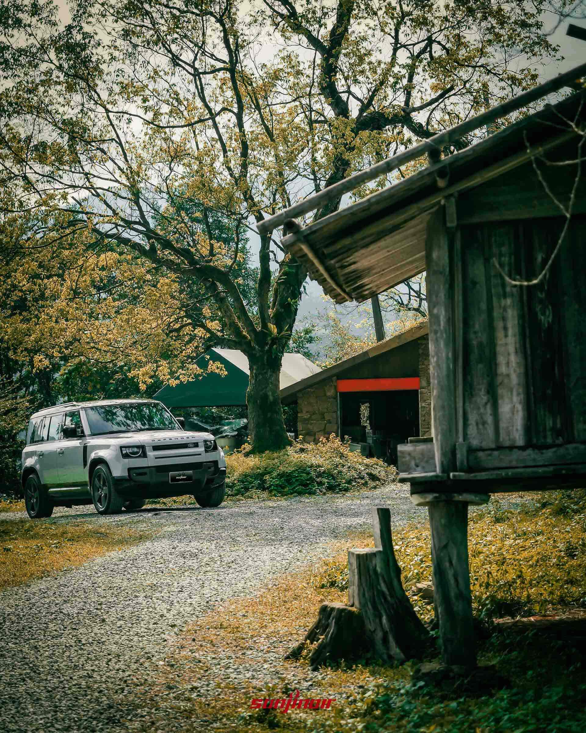 銀色Defender停放於碎石路上右側為傳統架高穀倉。