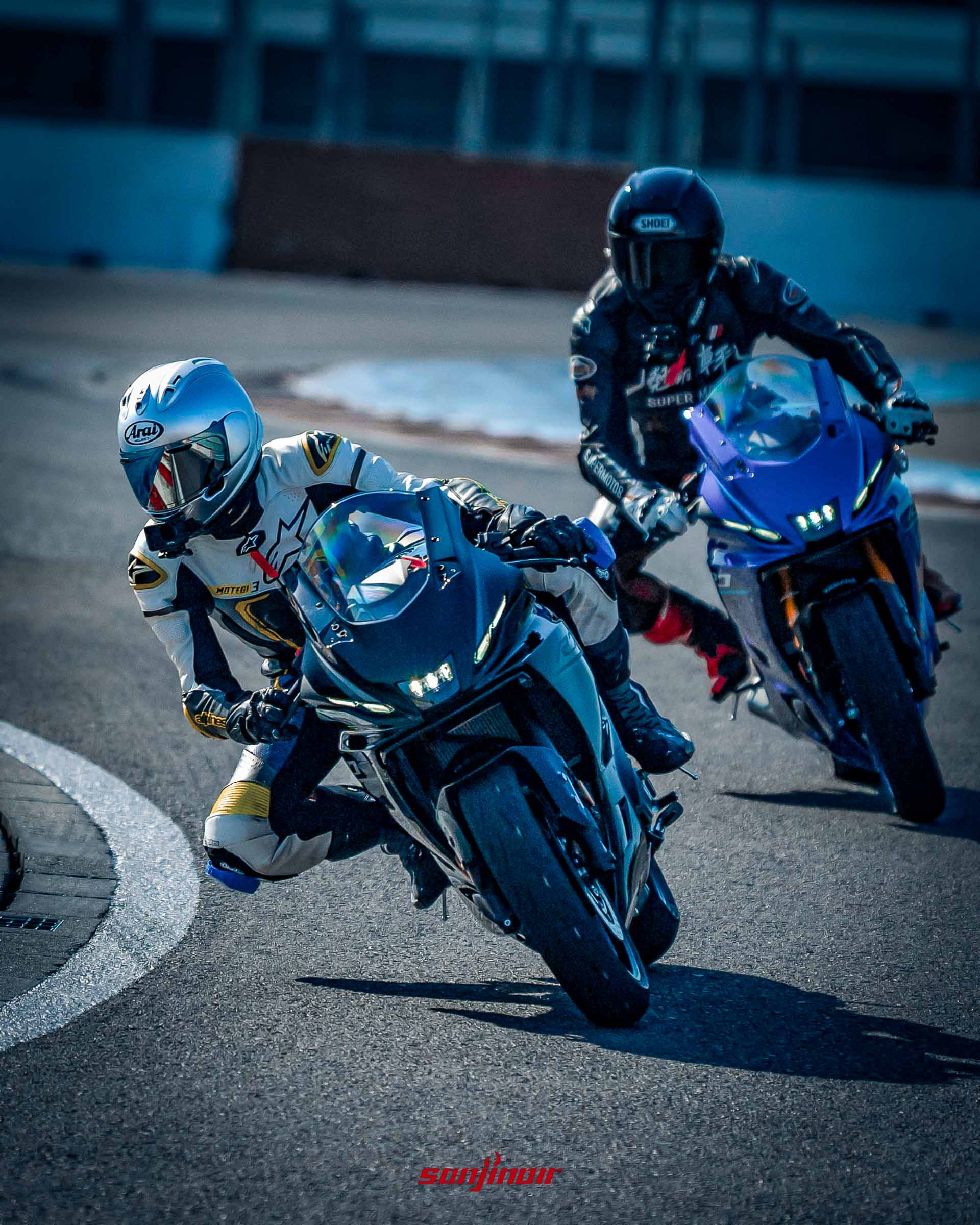 賽道動態追焦照,前方騎士駕駛黑色的YZF-R9帶頭過彎,後方緊跟著另一名駕駛藍色YZF-R7的騎士。