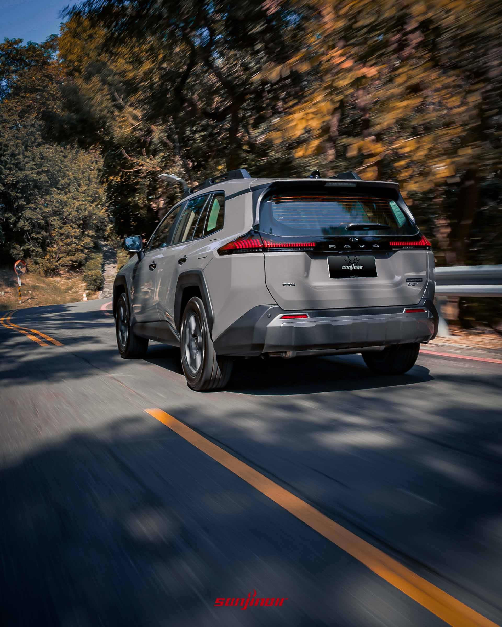 RAV4 Adventure 行駛於山路的車尾動態照片，展示行駛姿態。