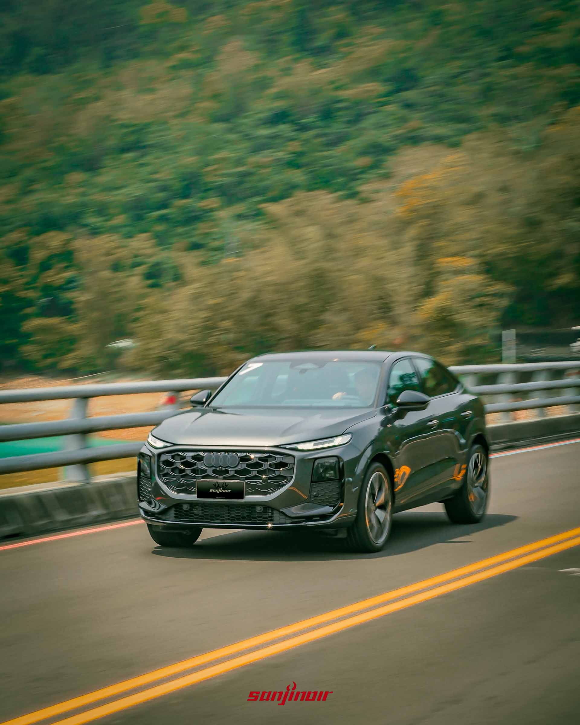 Audi Q3行駛於筆直公路上的動態追焦照片，展現動感流線的車身比例。