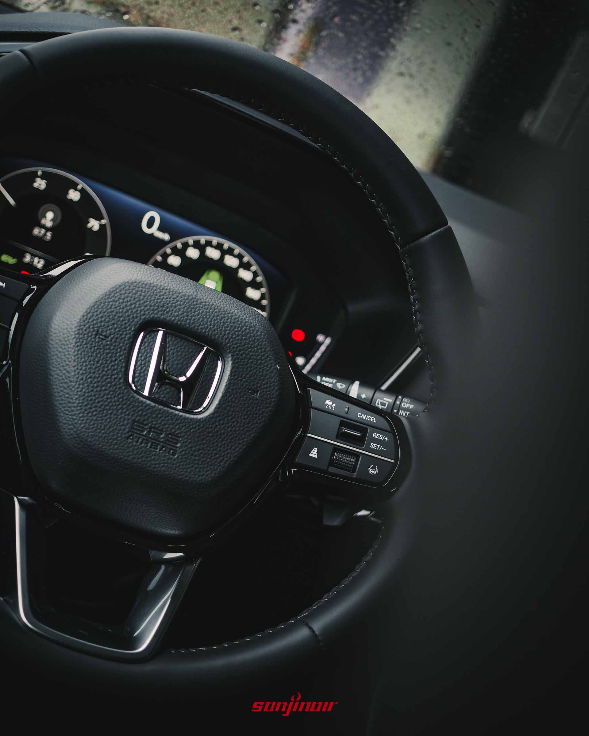 HONDA CR-V皮質方向盤的近距離特寫,正中央為經典的鍍鉻H廠徽,右側則有煞車距調節與車道維持輔助按鍵。